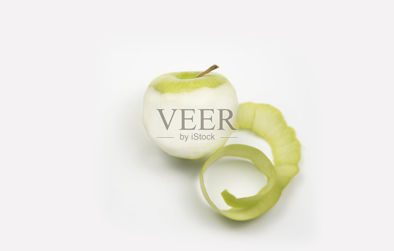 去皮的绿苹果，白色背景。苹果皮缠在一起照片摄影图片