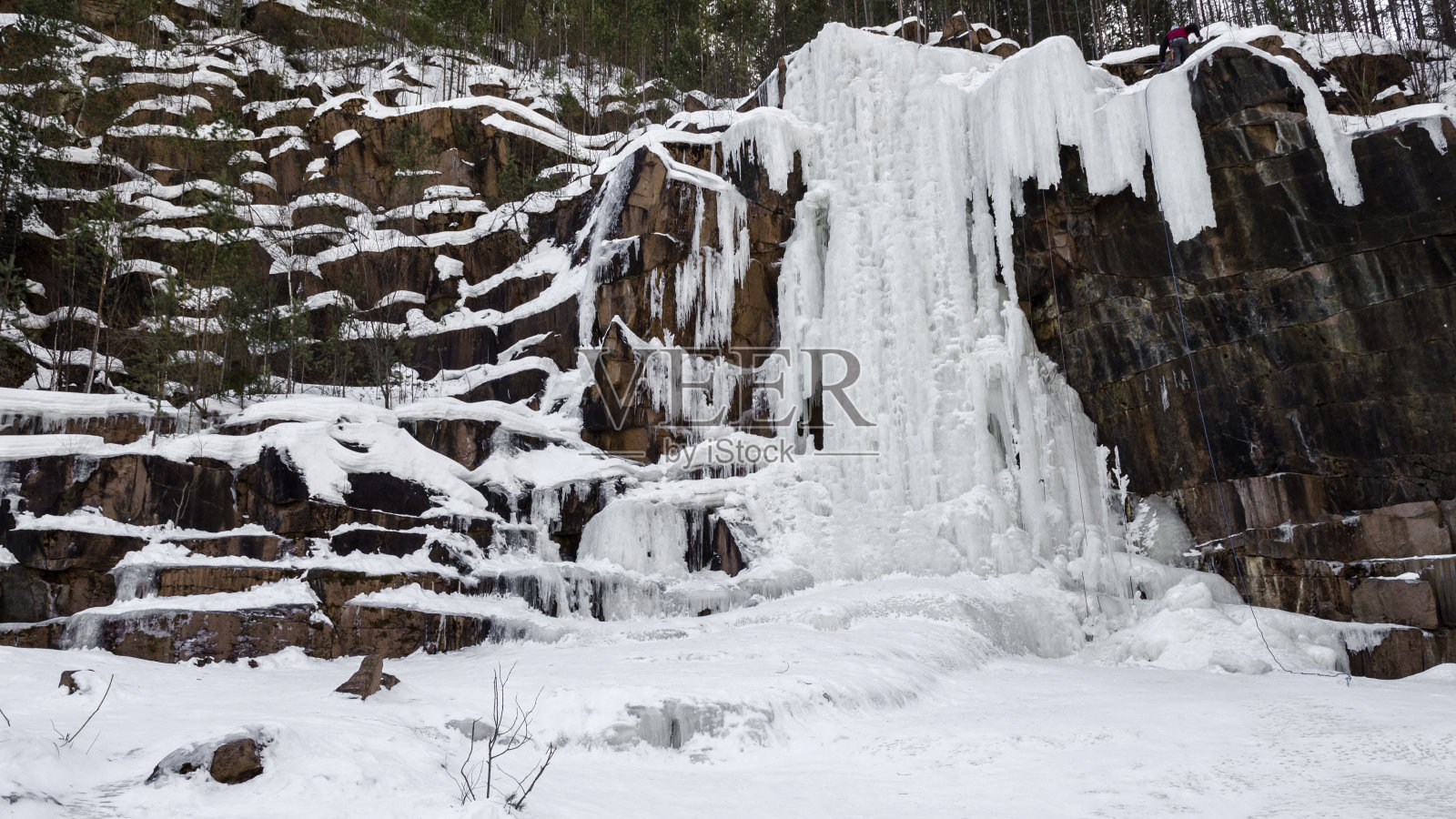 冰瀑是在陡峭的悬崖上用暗色的石头、冰冻的水形成的一种人工瀑布照片摄影图片