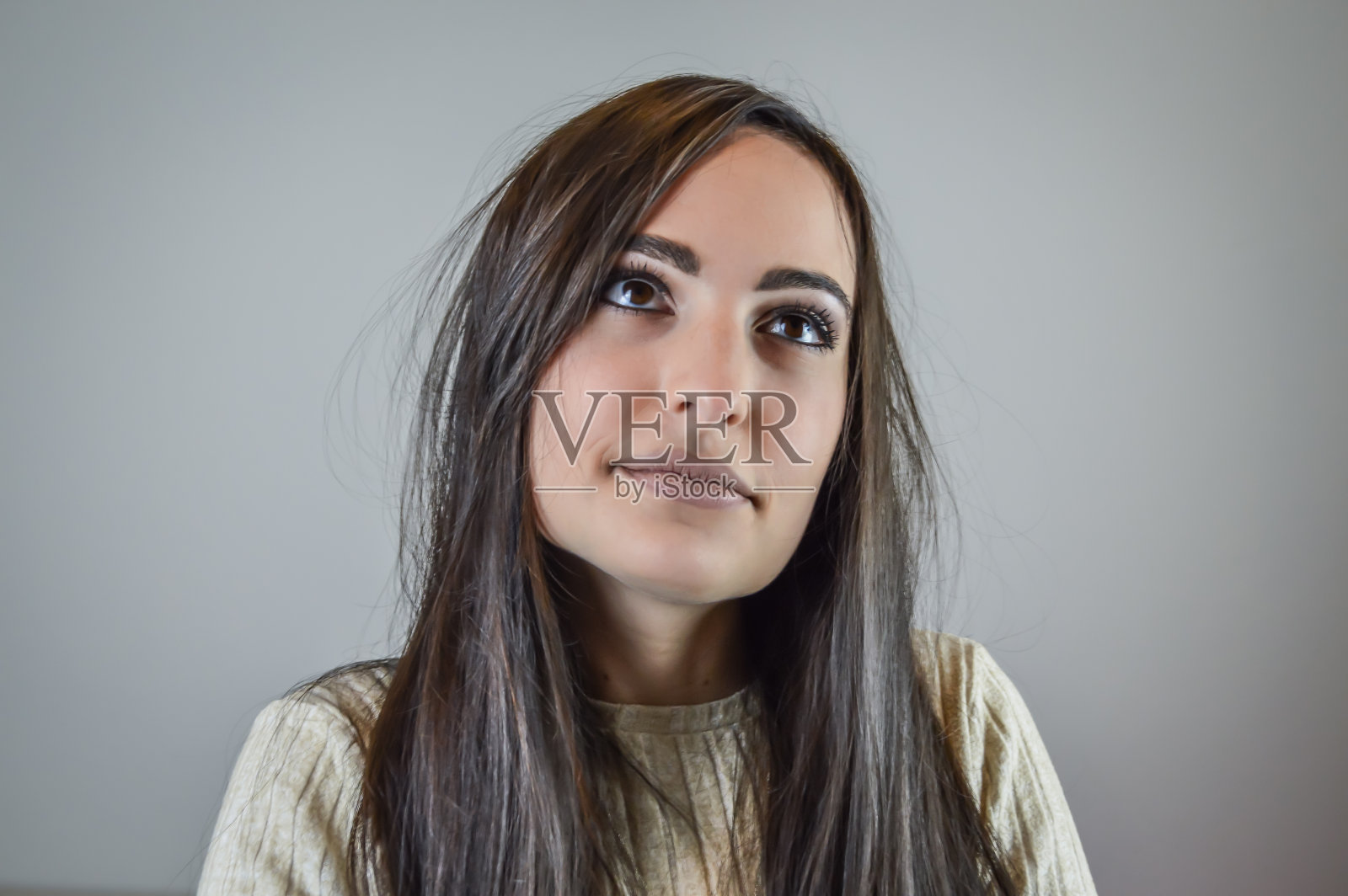 一个美丽的年轻女子的肖像与长棕色头发与梦幻的目光远离照片摄影图片