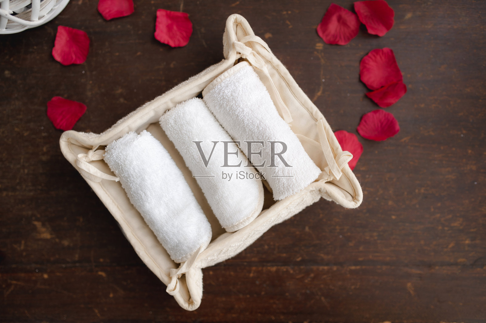 顶视图水疗组合与毛巾和花瓣在健康中心的桌子上。照片摄影图片