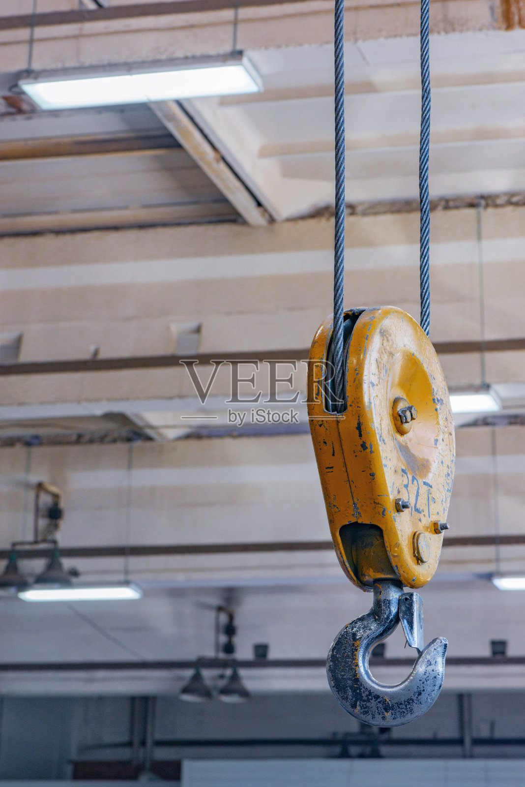 吊钩用链条吊在钢缆上。照片摄影图片