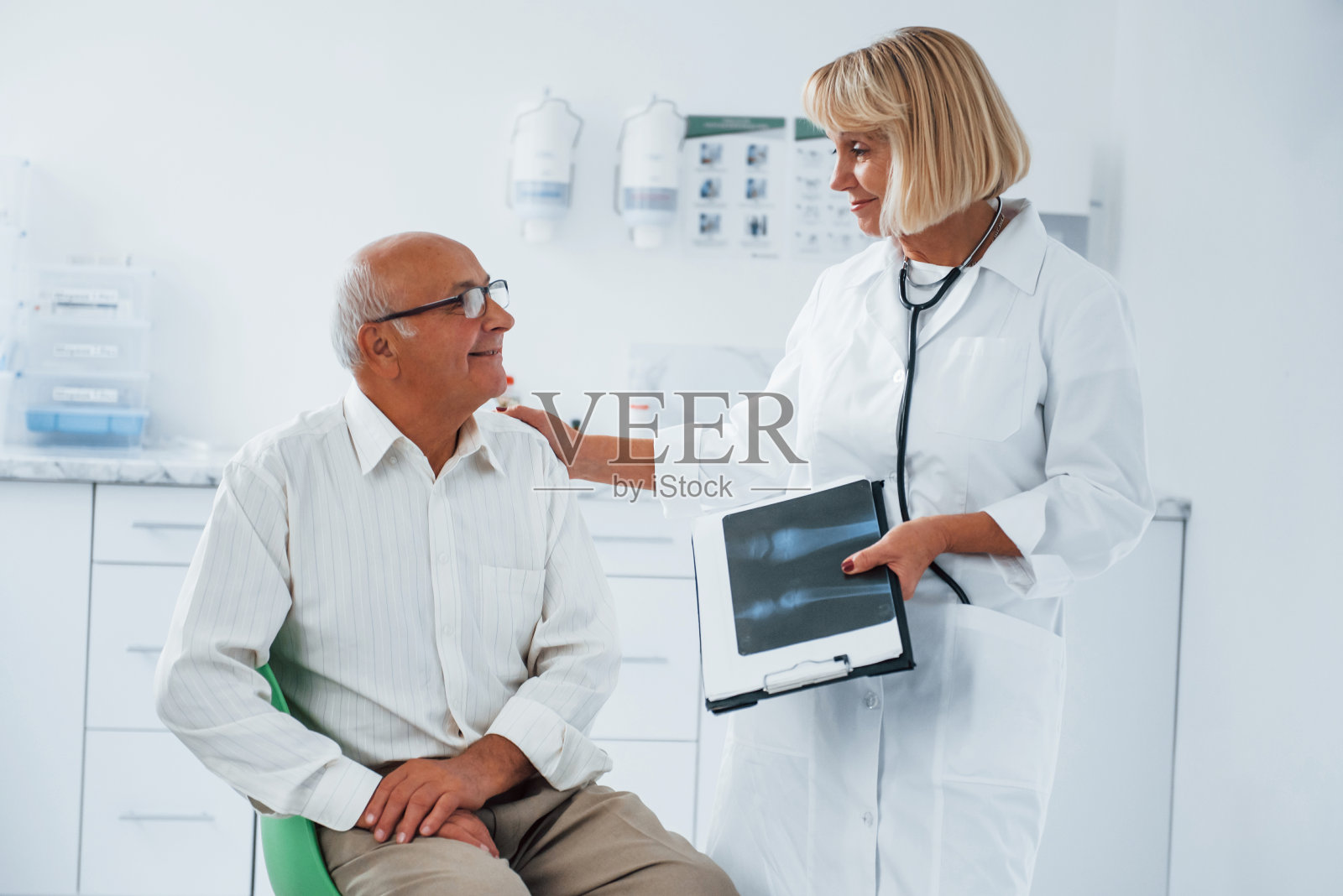资深男士在诊所由女医生会诊照片摄影图片