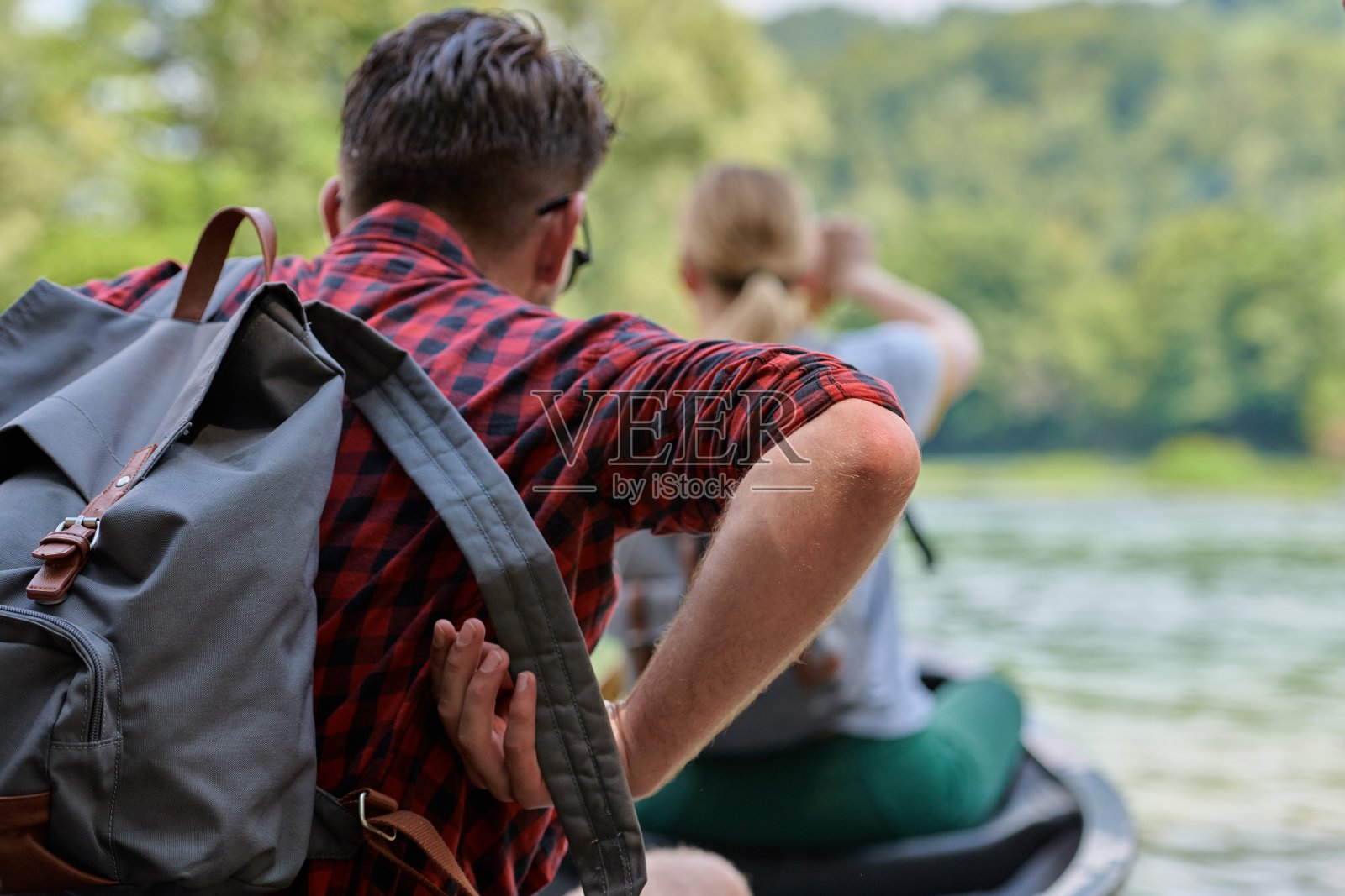 朋友们在湍急的河流里划独木舟照片摄影图片
