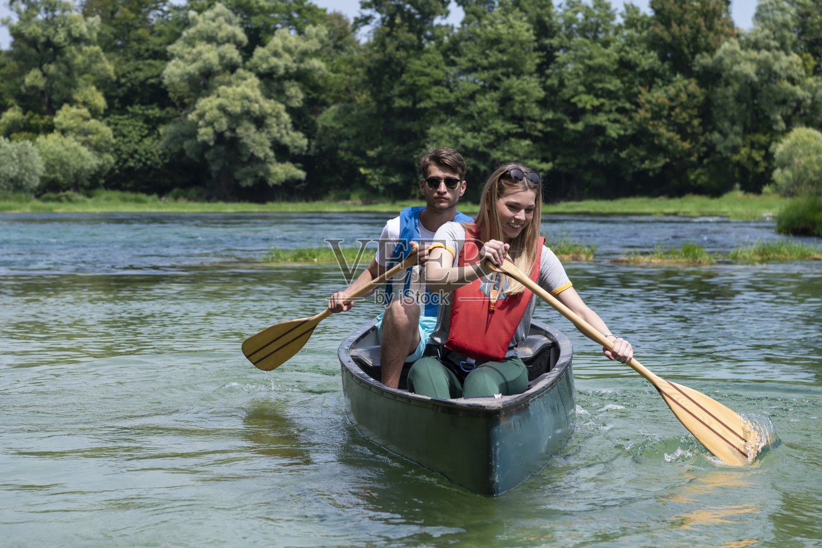 朋友们在湍急的河流里划独木舟照片摄影图片