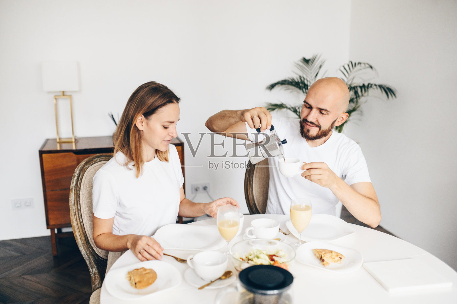 年轻幸福的夫妇在家里一起吃早餐照片摄影图片