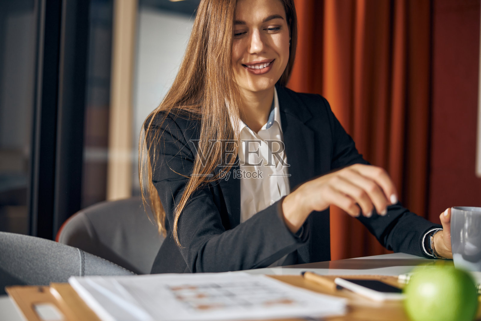 微笑的设计师正在她的办公室喝咖啡休息照片摄影图片