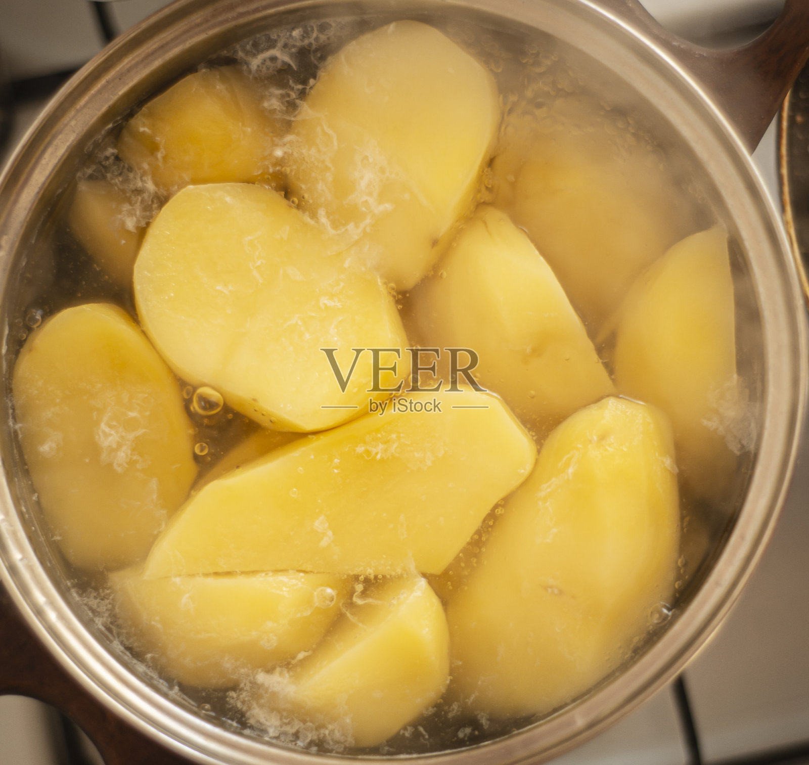 用炖锅煮土豆，用炉子煮土豆，照片摄影图片