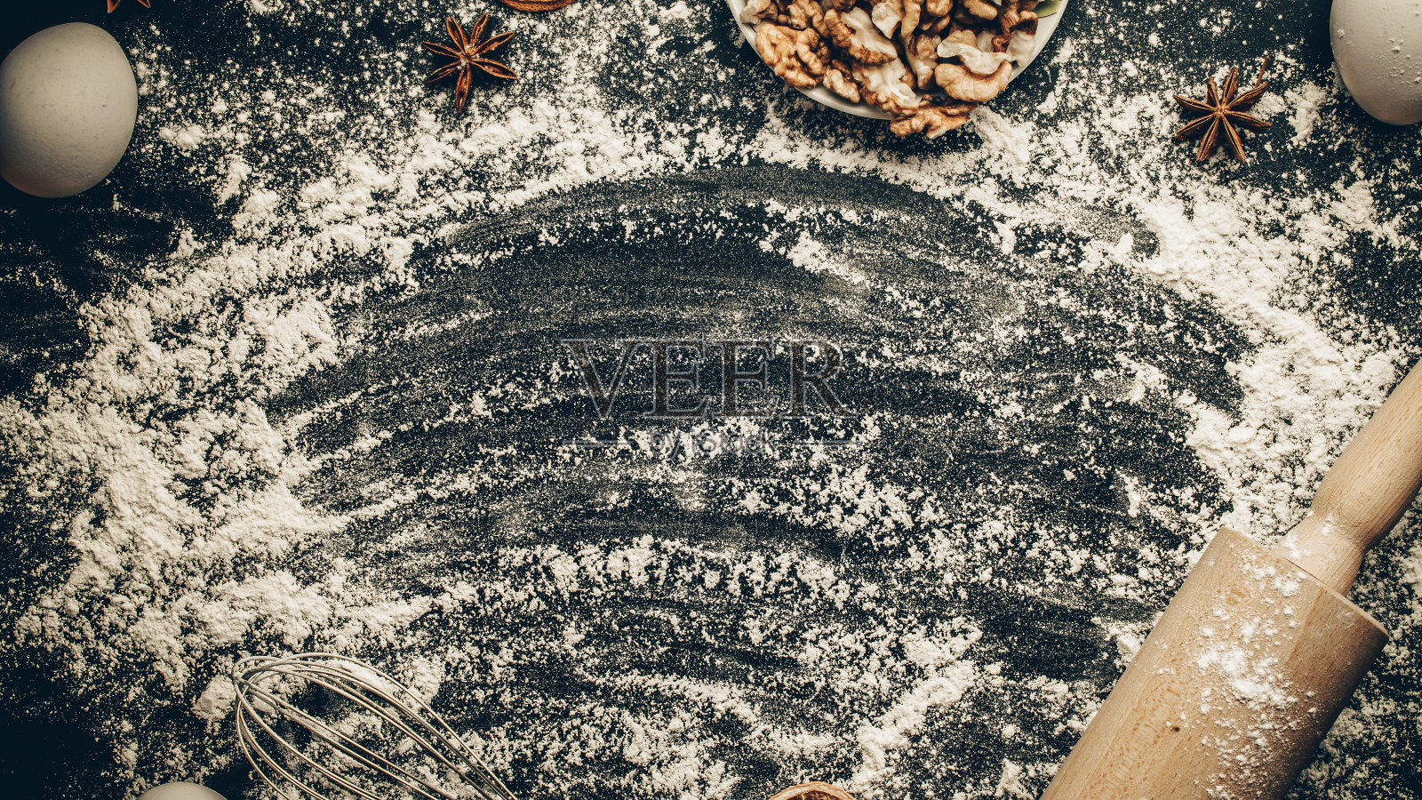 面包店的背景。烹饪食物配料:面粉，鸡蛋，坚果和八角，橙色在黑暗的餐桌厨房背景蛋糕。厨房食品框架。照片摄影图片
