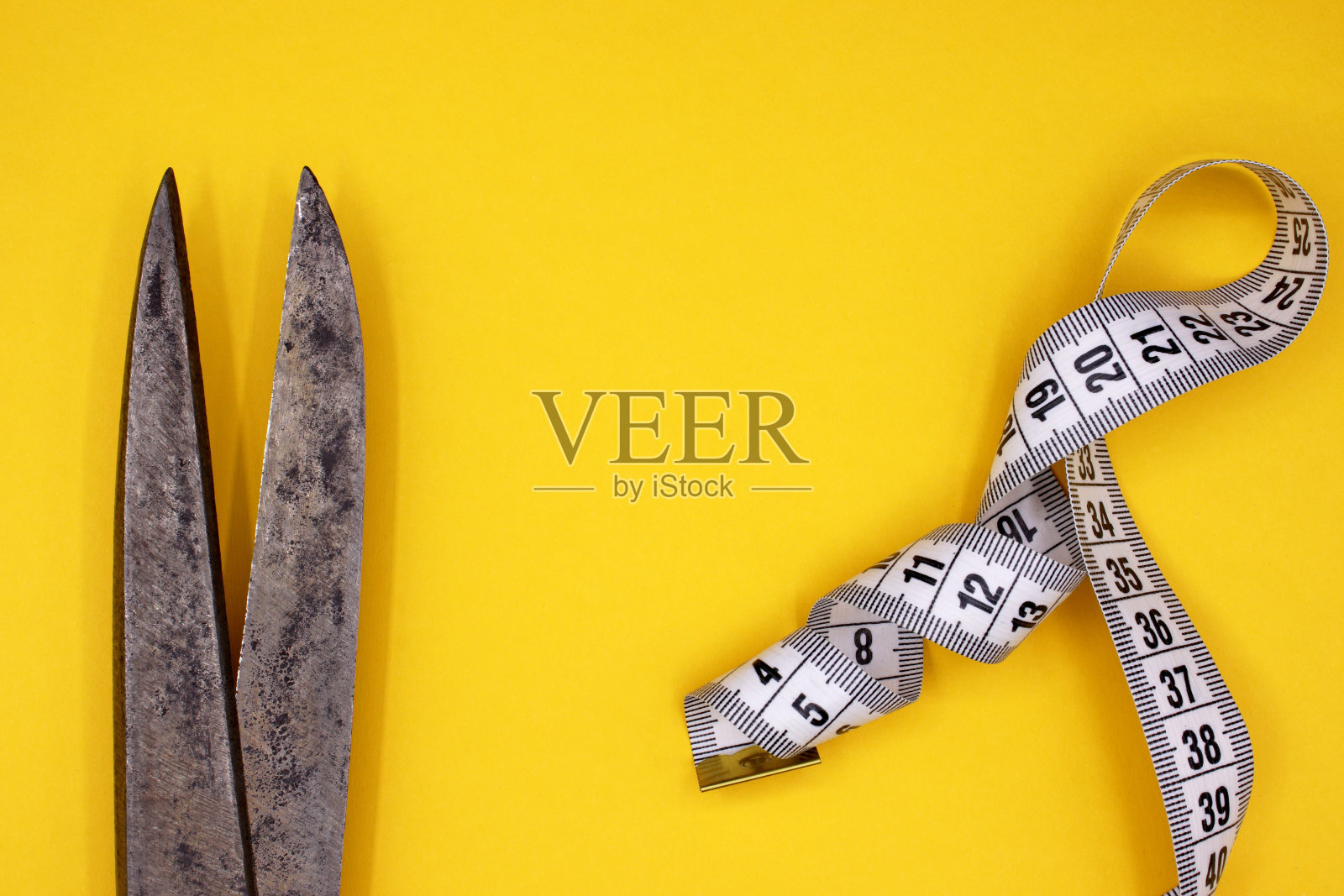 彩色背景上的卷尺和剪刀照片摄影图片