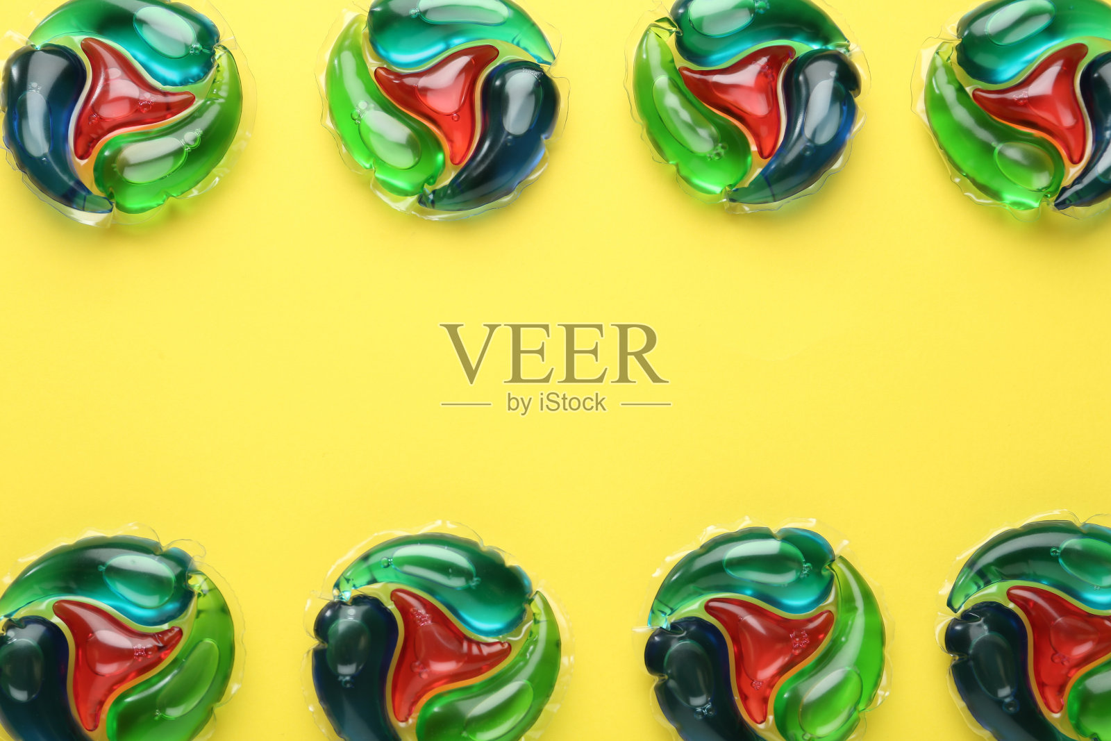 洗衣胶囊在黄色背景上，平铺。空间的文本照片摄影图片