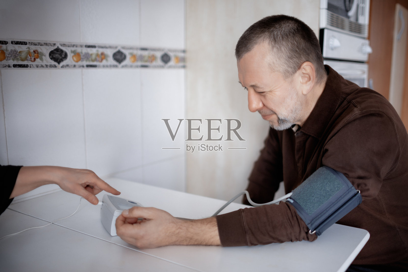 男子在家中测量血压照片摄影图片