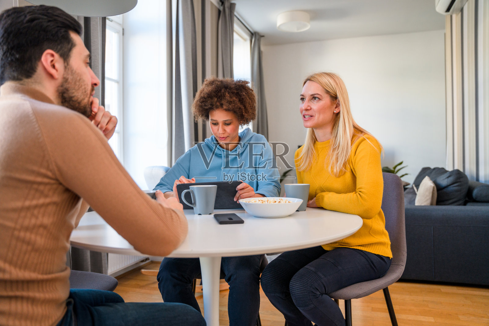 微笑的朋友使用数字平板电脑和一起在餐厅里玩照片摄影图片