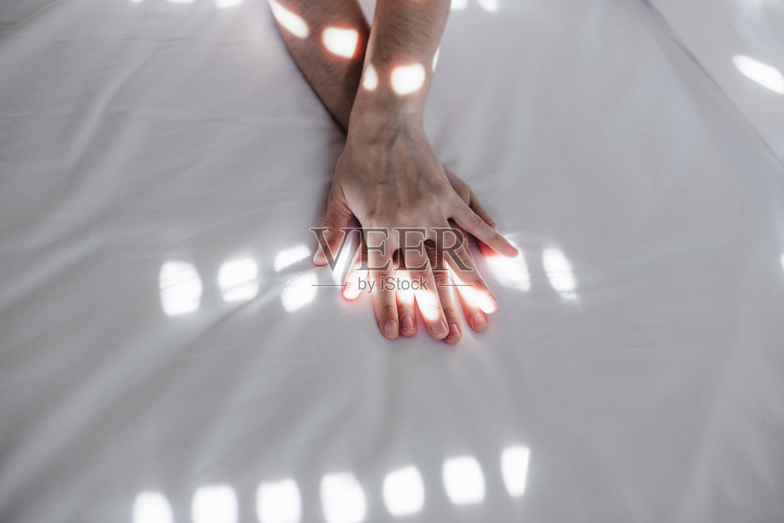 迷人的年轻白种女人的肖像在床上放松在早上的时间。女士喜欢卧室里新鲜柔软的被褥和床垫。手上的阴影照片摄影图片