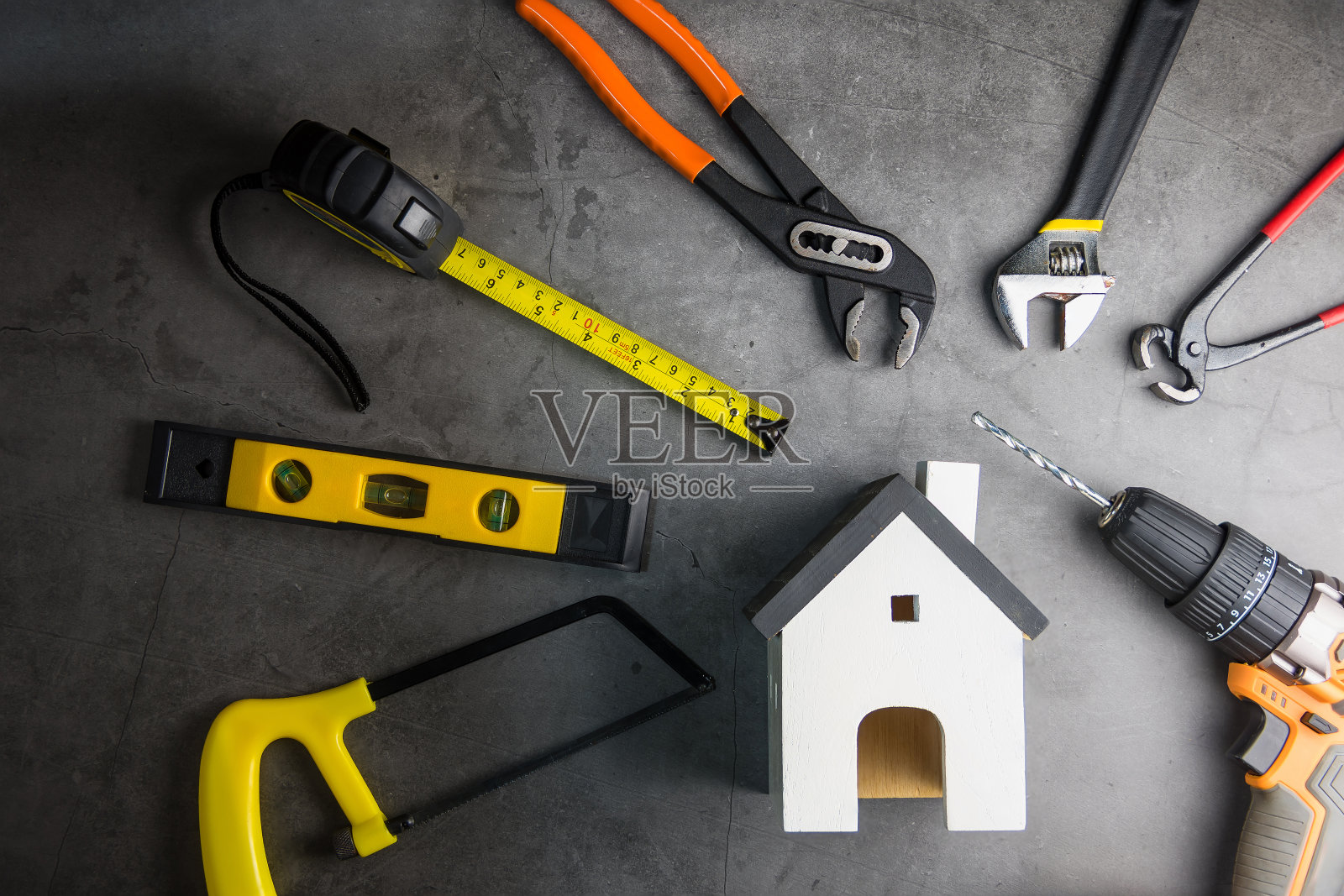 木制的白色房屋玩具和建筑工具，灰色的水泥地板背景与复制空间。房地产概念，新房子。家修复概念照片摄影图片