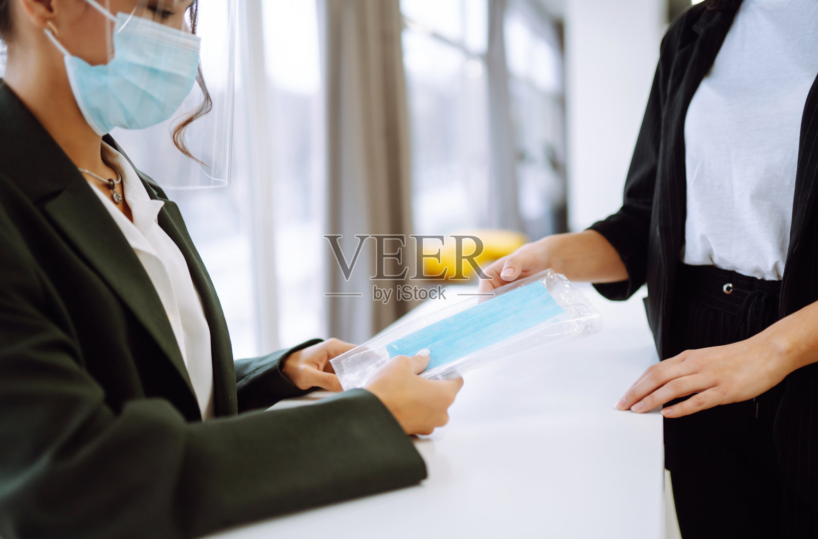 秘书给办公室员工发放无菌防护口罩。商务人员在隔离后回到办公室工作。新型冠状病毒肺炎照片摄影图片