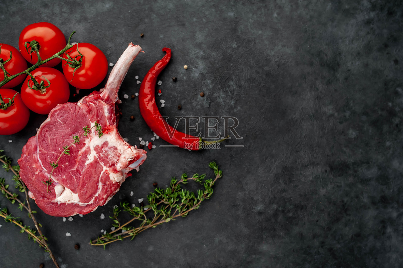 生牛排，香料牛肉斧，石头背景上的百里香。为你的文本留出拷贝空间照片摄影图片