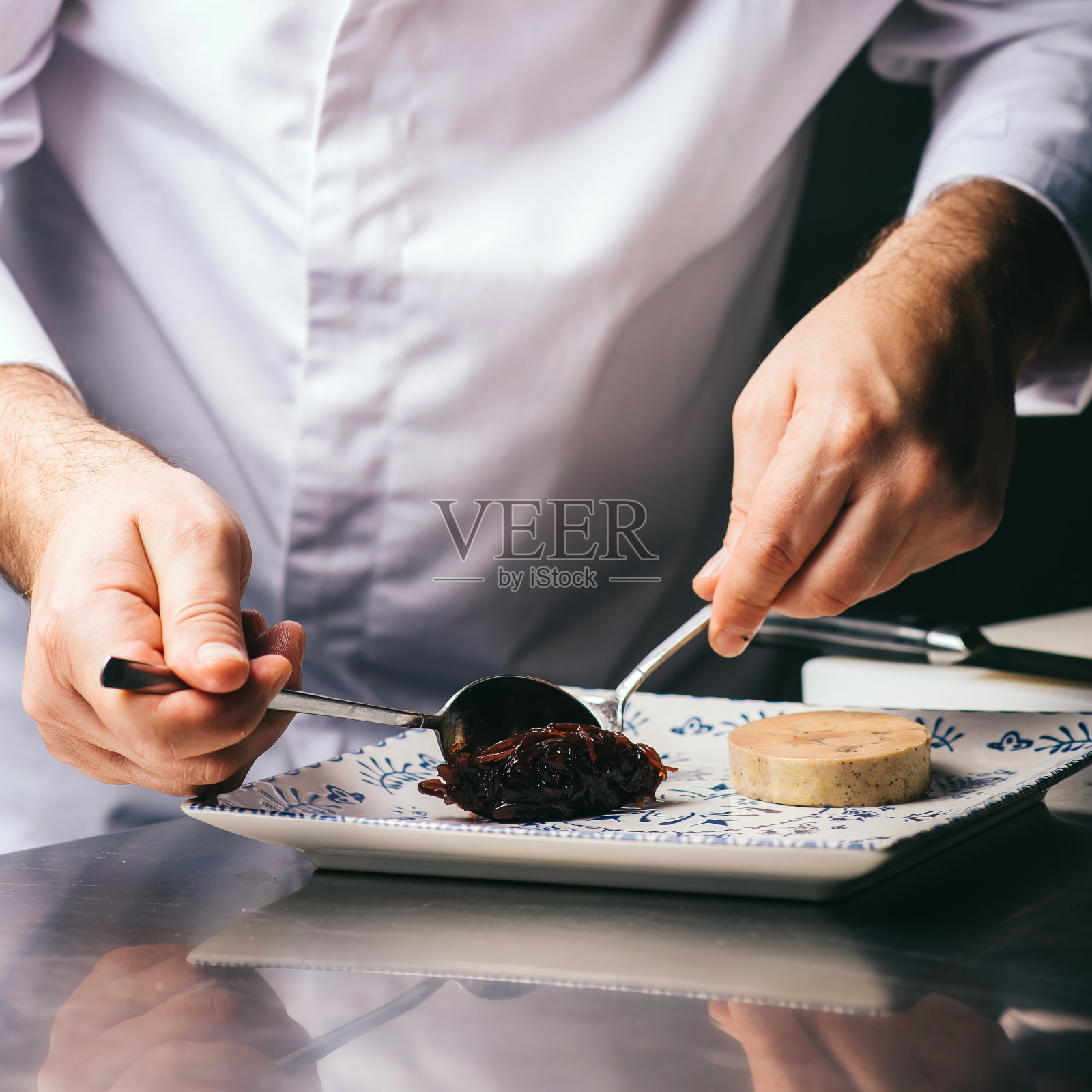 厨师在装饰一盘鹅肝酱照片摄影图片