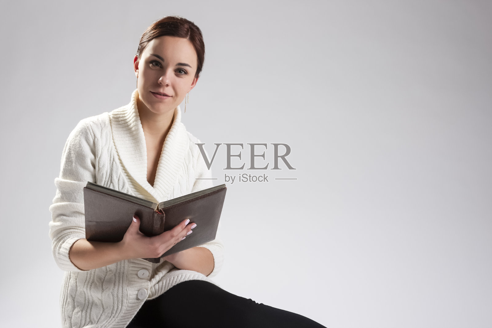 年轻白人女性坐着看书的肖像。水平的形象照片摄影图片