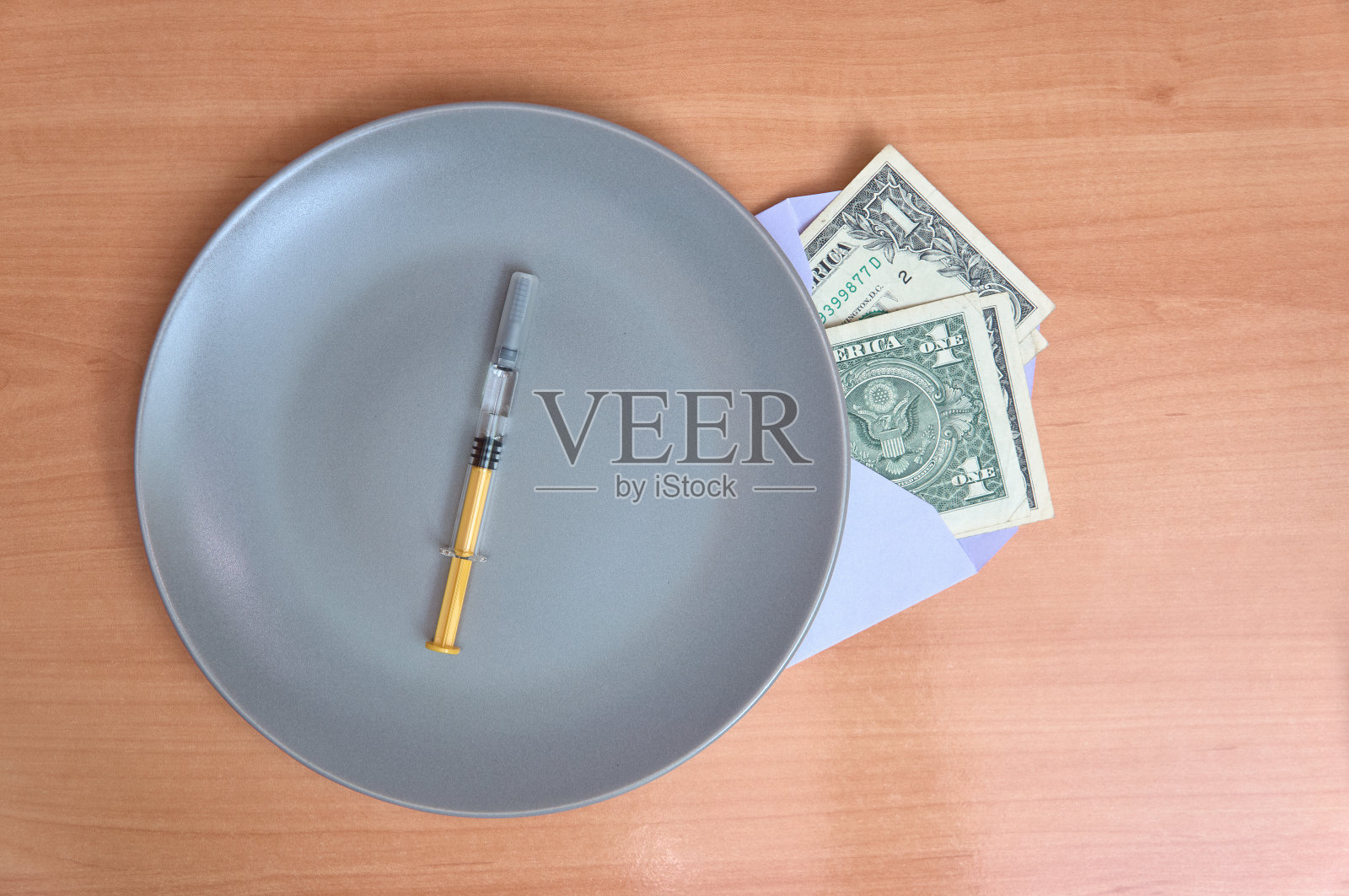 盘子上的注射器还有一个装着美元的信封。推测和疫苗交易照片摄影图片