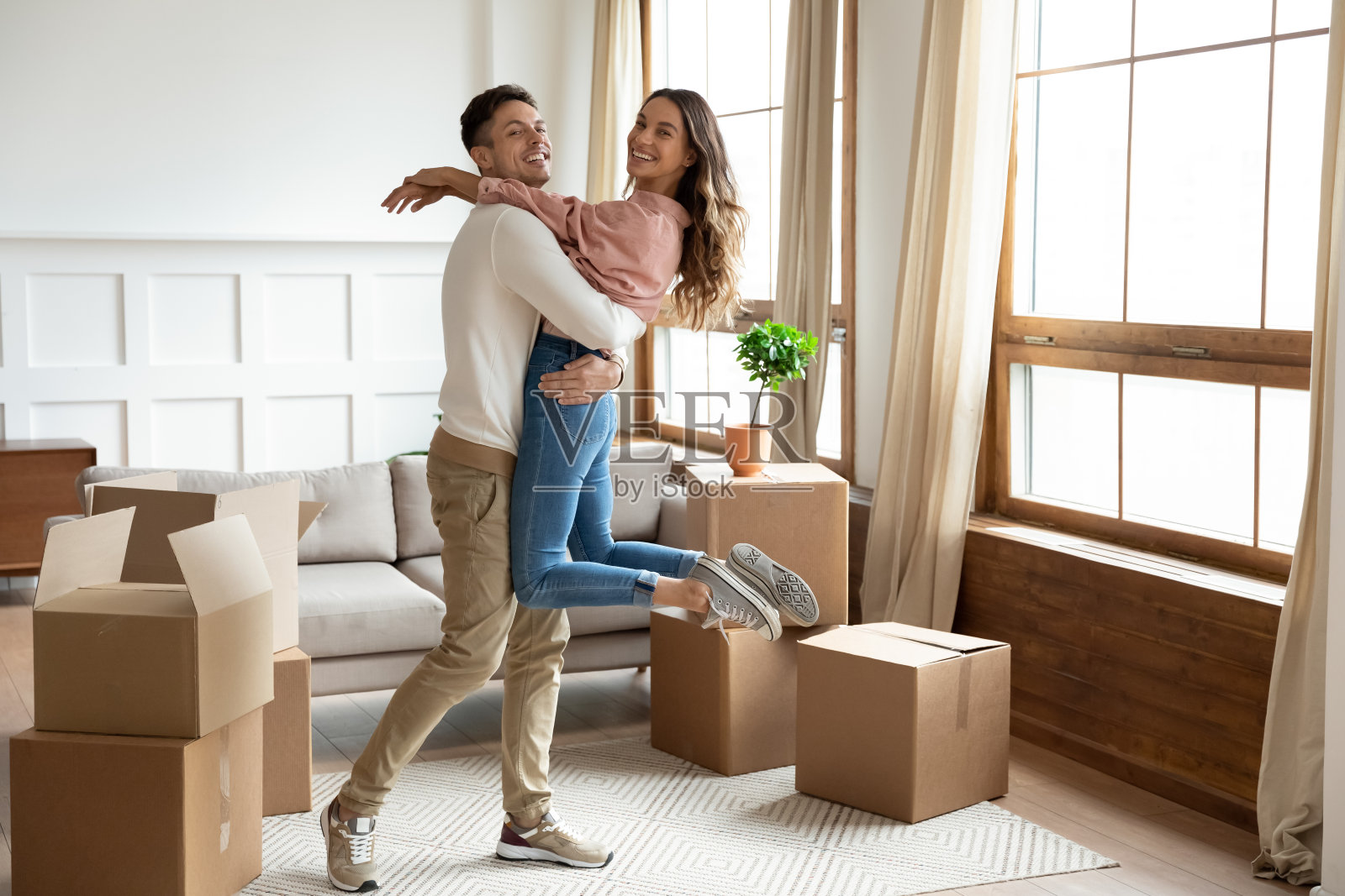 丈夫举起妻子庆祝新家搬迁日照片摄影图片