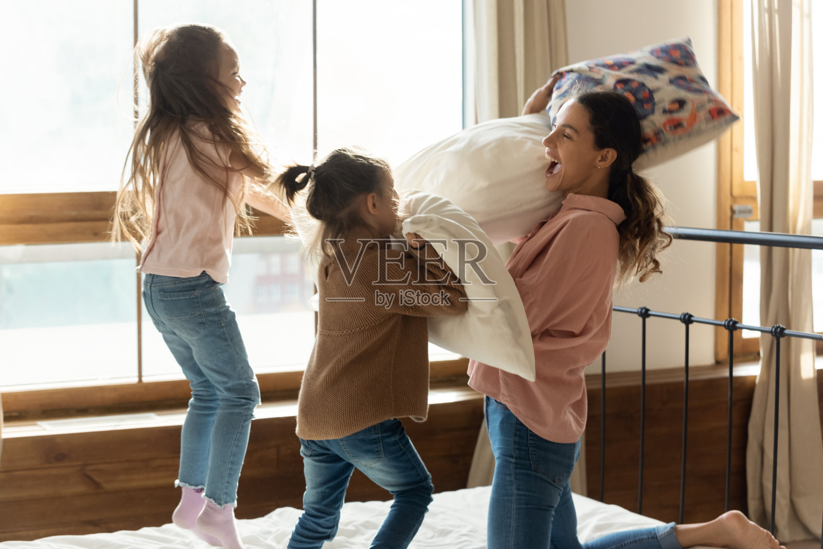 年轻的母亲和两个可爱的女儿玩耍照片摄影图片