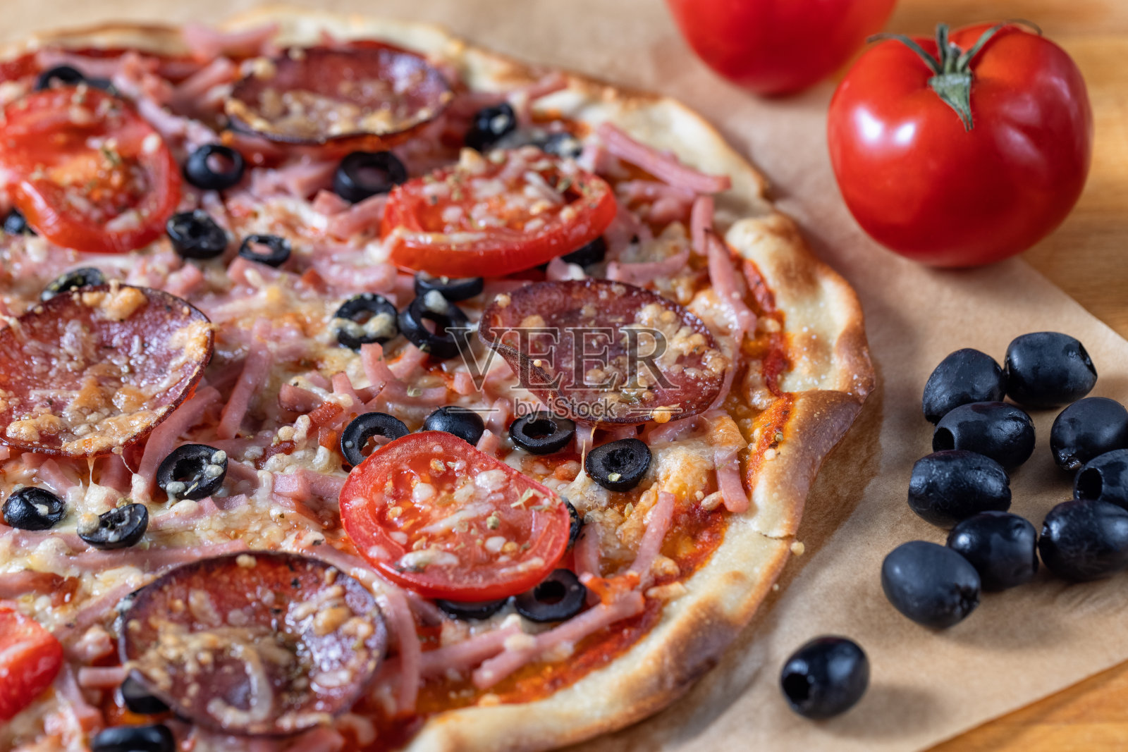 自制披萨配意大利腊肠，火腿和橄榄，特写镜头照片摄影图片