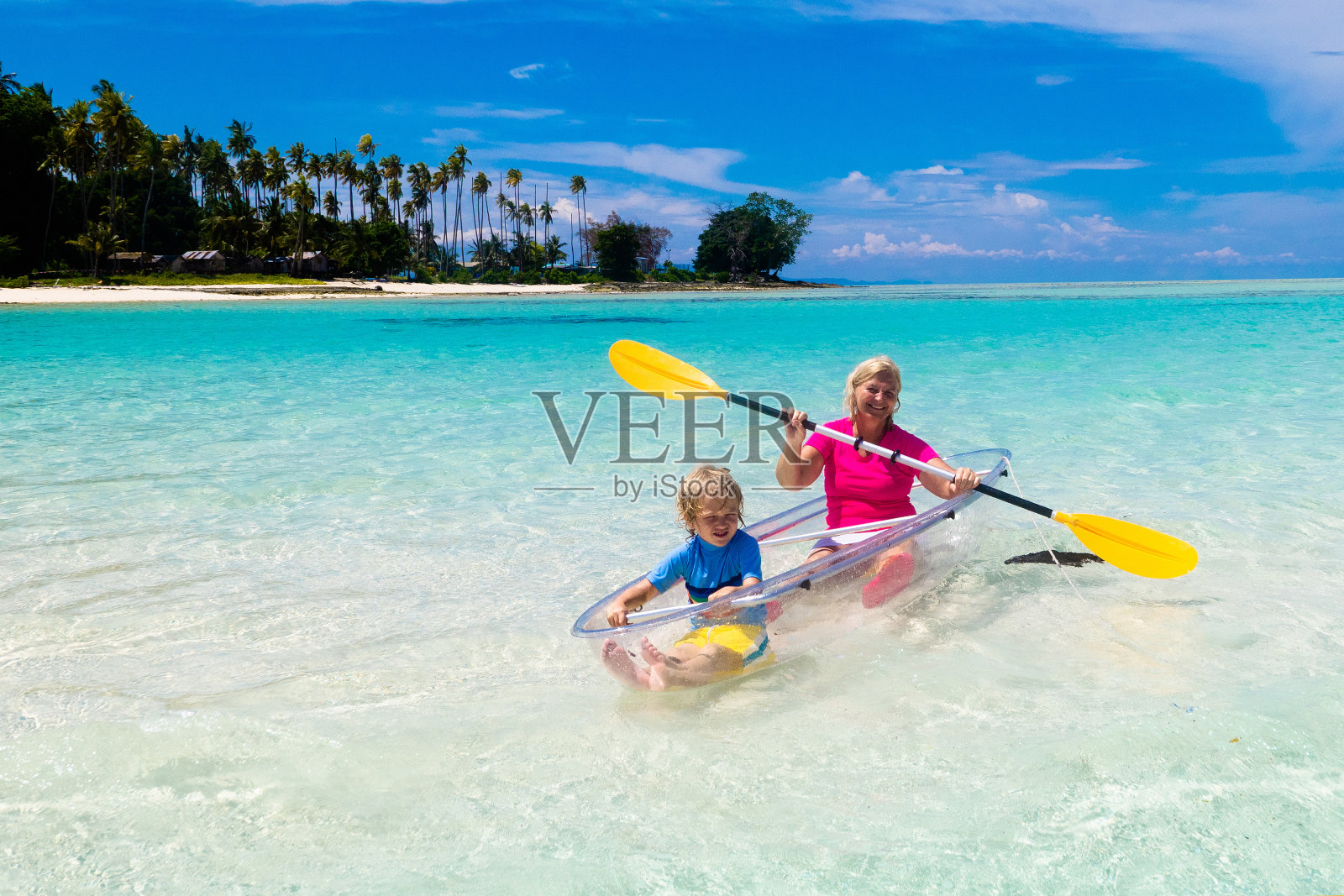 孩子们在海里划皮艇。一家人在热带海上的皮艇上照片摄影图片