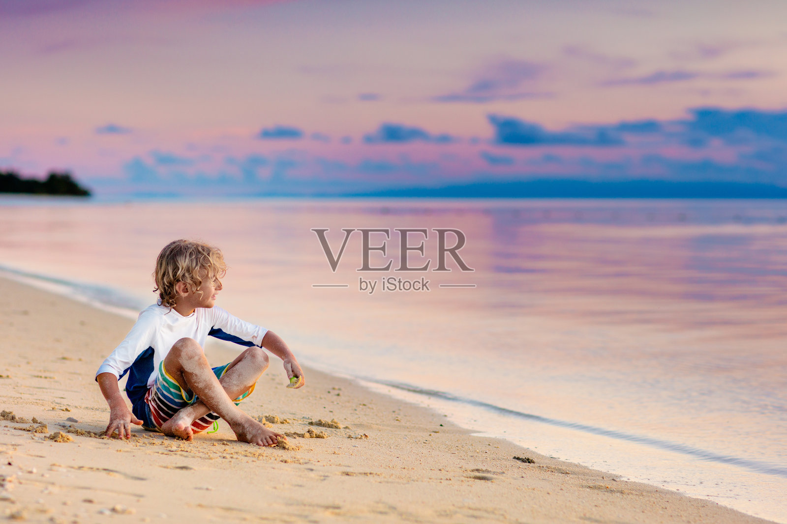 孩子们在海滩上玩耍。夕阳下的孩子。照片摄影图片