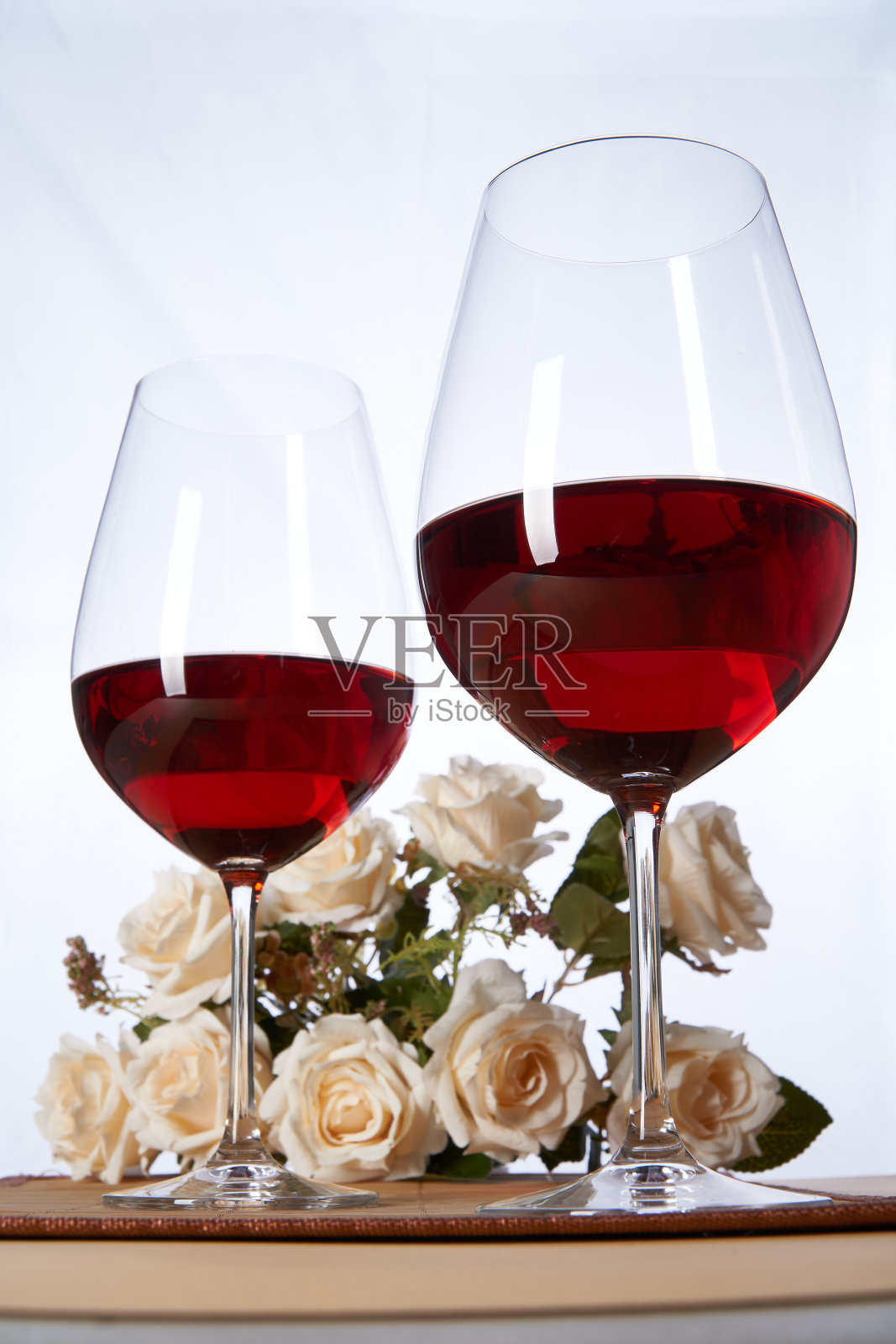 酒杯配红酒，背景是花和垫子照片摄影图片