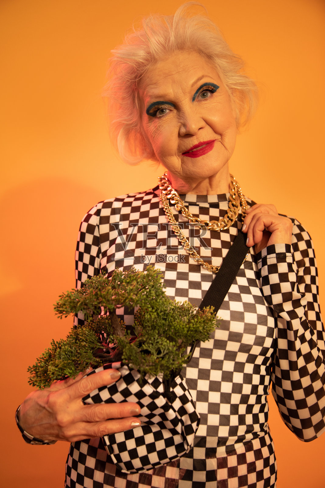 一个女人拿着她的包，而花时间在工作室照片摄影图片