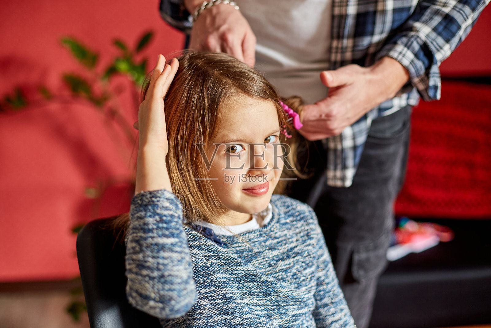 父亲在家里梳头，给女儿梳头，孩子做鬼脸，揪头发照片摄影图片