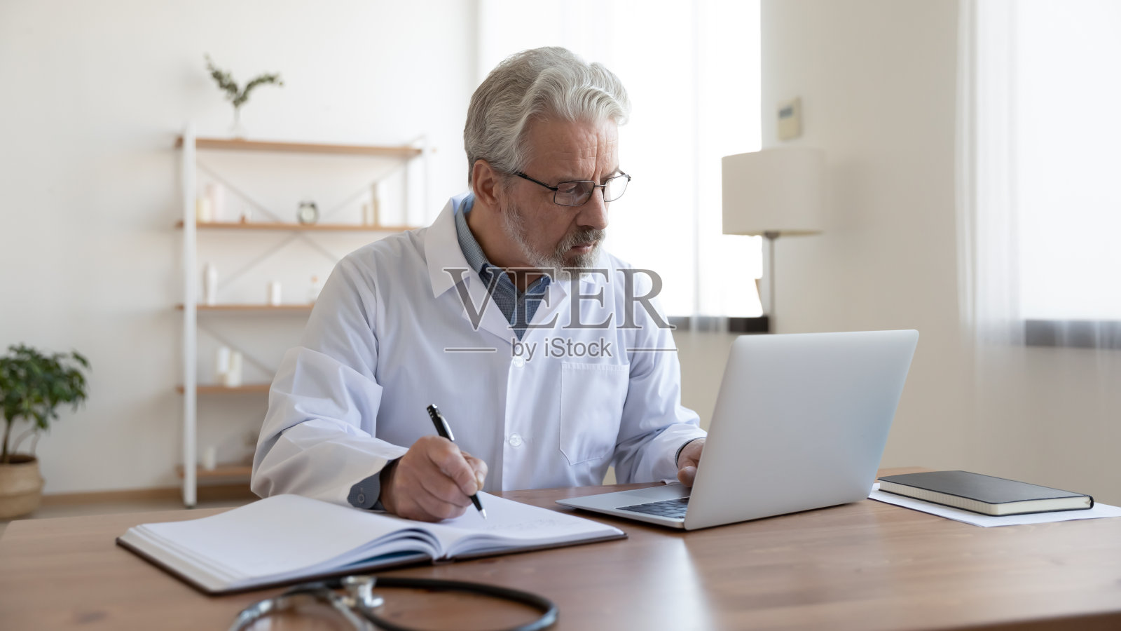 成熟的男医生在临床工作中使用计算机照片摄影图片