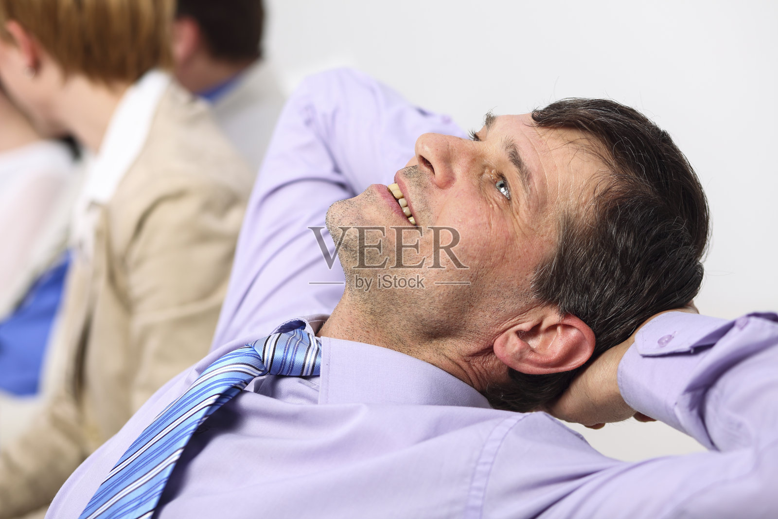 快乐的商人，双手放在脑后照片摄影图片