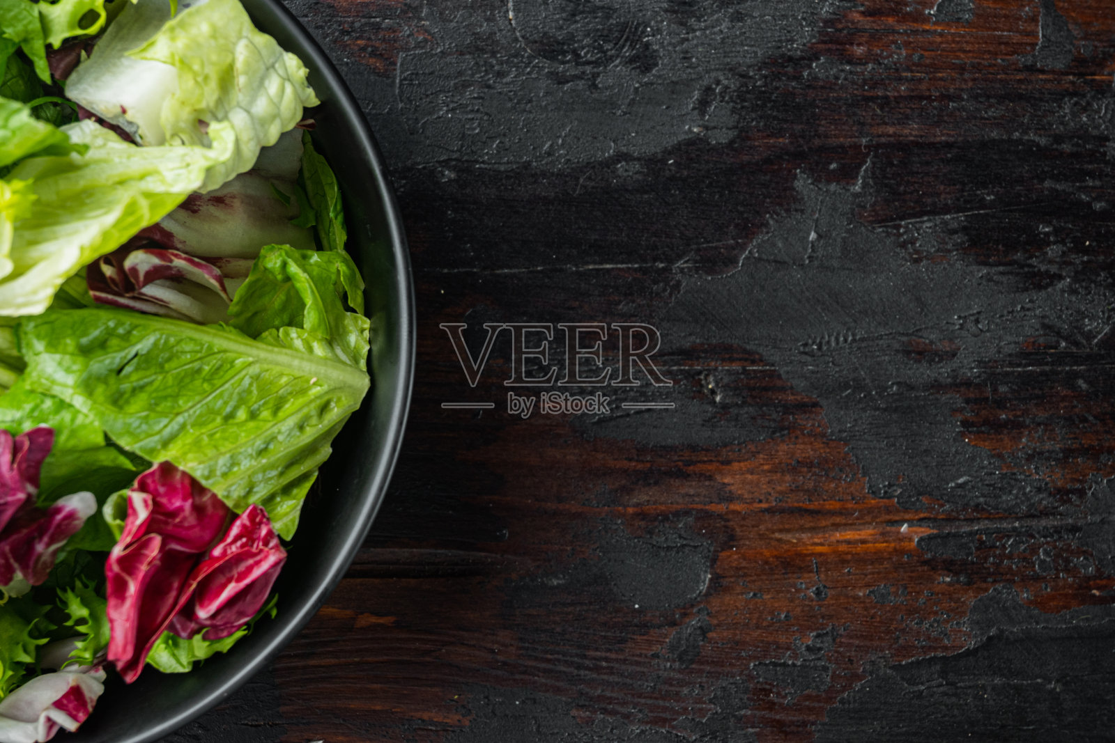 粗条、长叶莴苣和菊苣，放在旧的深色木桌的背景上，平放俯视图，留出文字的空间照片摄影图片