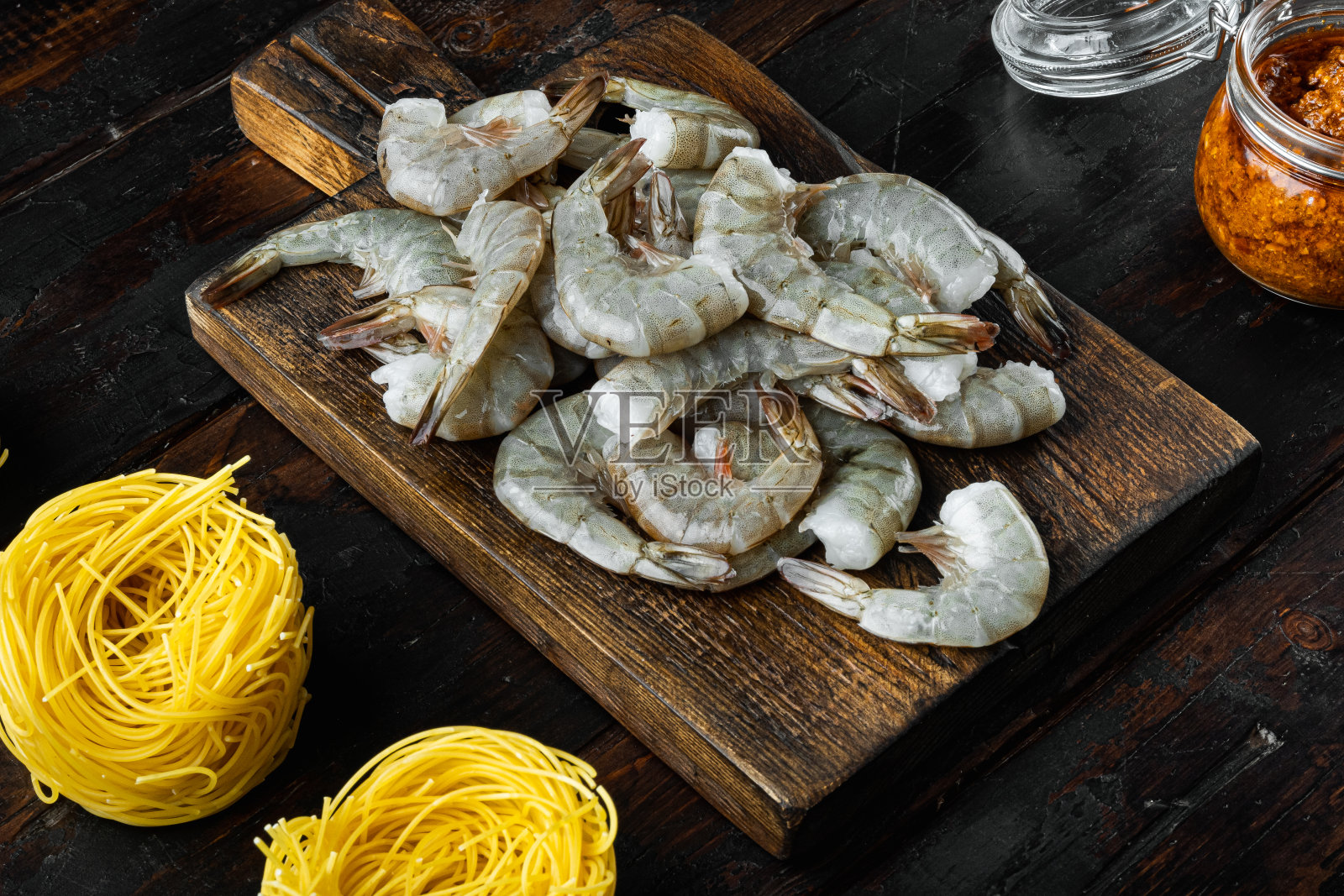 用红色香蒜沙司和虾做的意大利面，放在旧的深色木桌上照片摄影图片