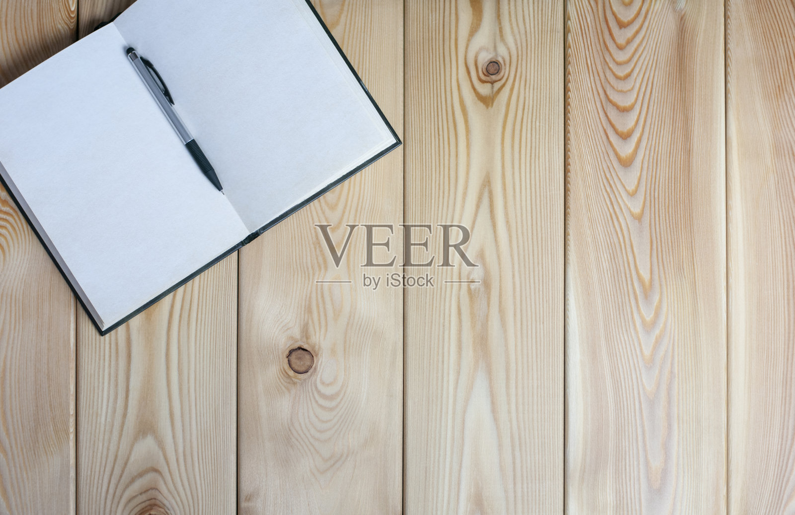 用黑色钢笔打开笔记本放在木桌上照片摄影图片