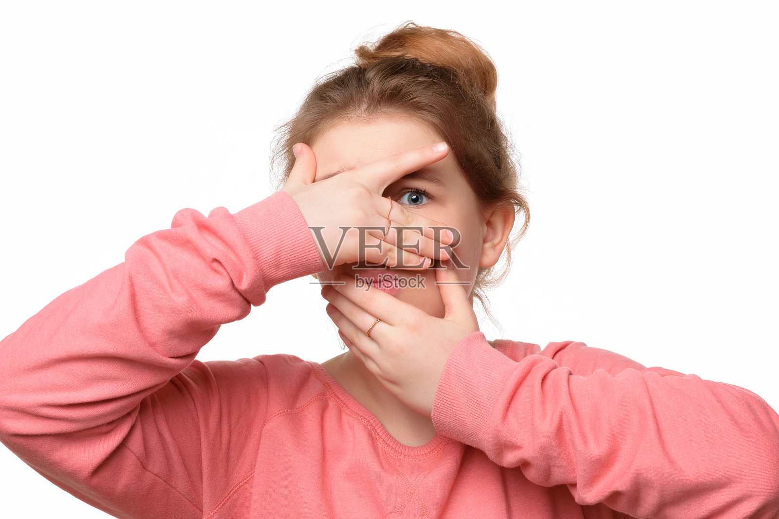 近害怕的十几岁的女孩隐藏在手掌的脸手和凝视与一只眼睛之间的手指，颤抖的恐惧照片摄影图片