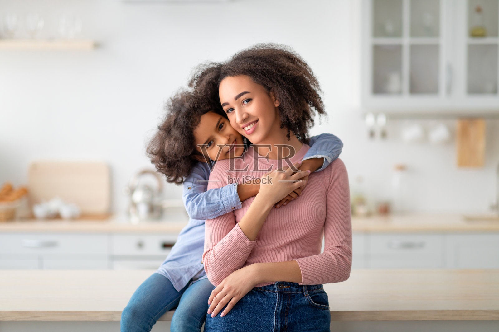 非裔美国人女儿从后面拥抱她微笑的妈妈照片摄影图片