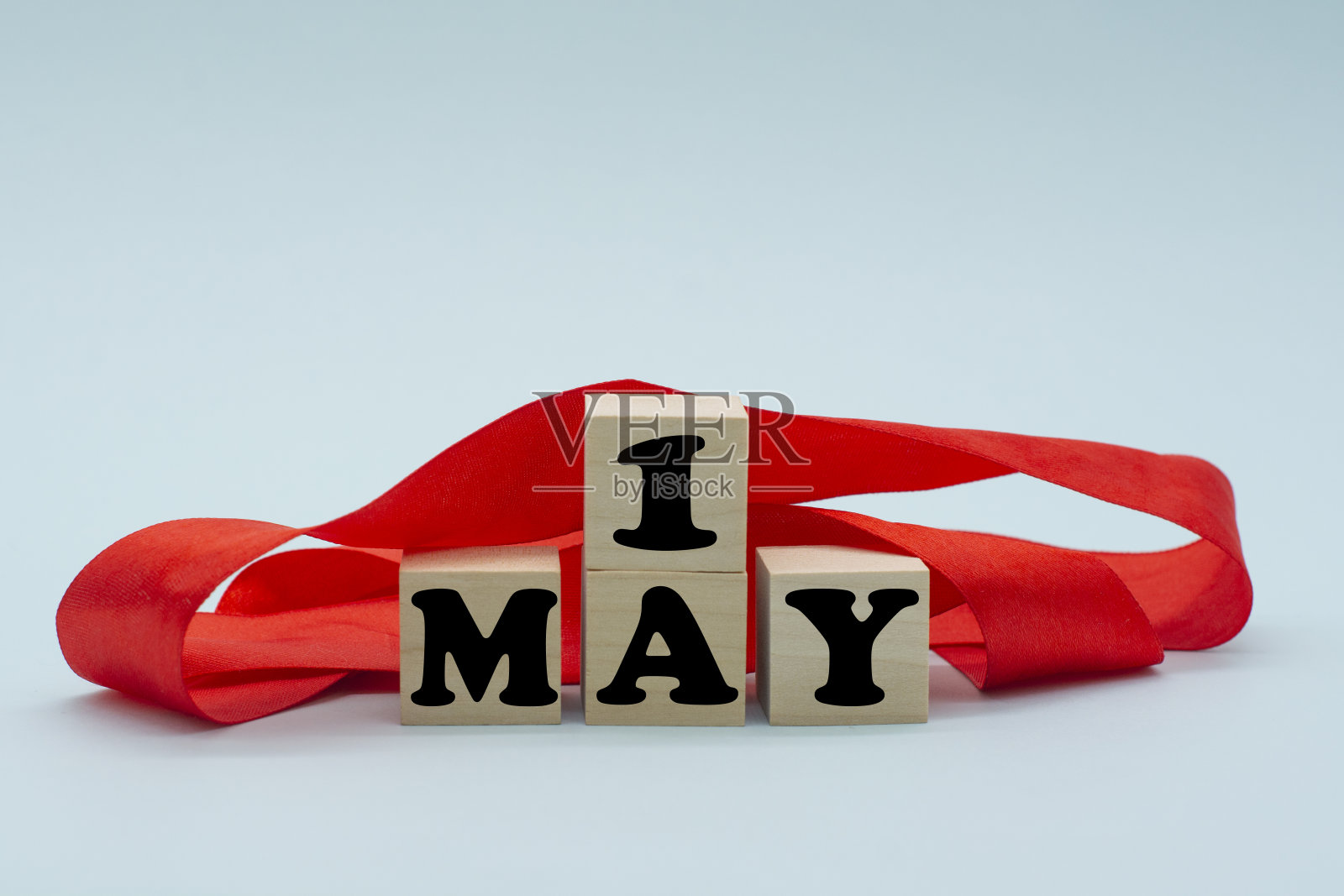 5月1日的文字用红丝带放在木方上。劳动节、国际工人团结日、五一概念照片摄影图片