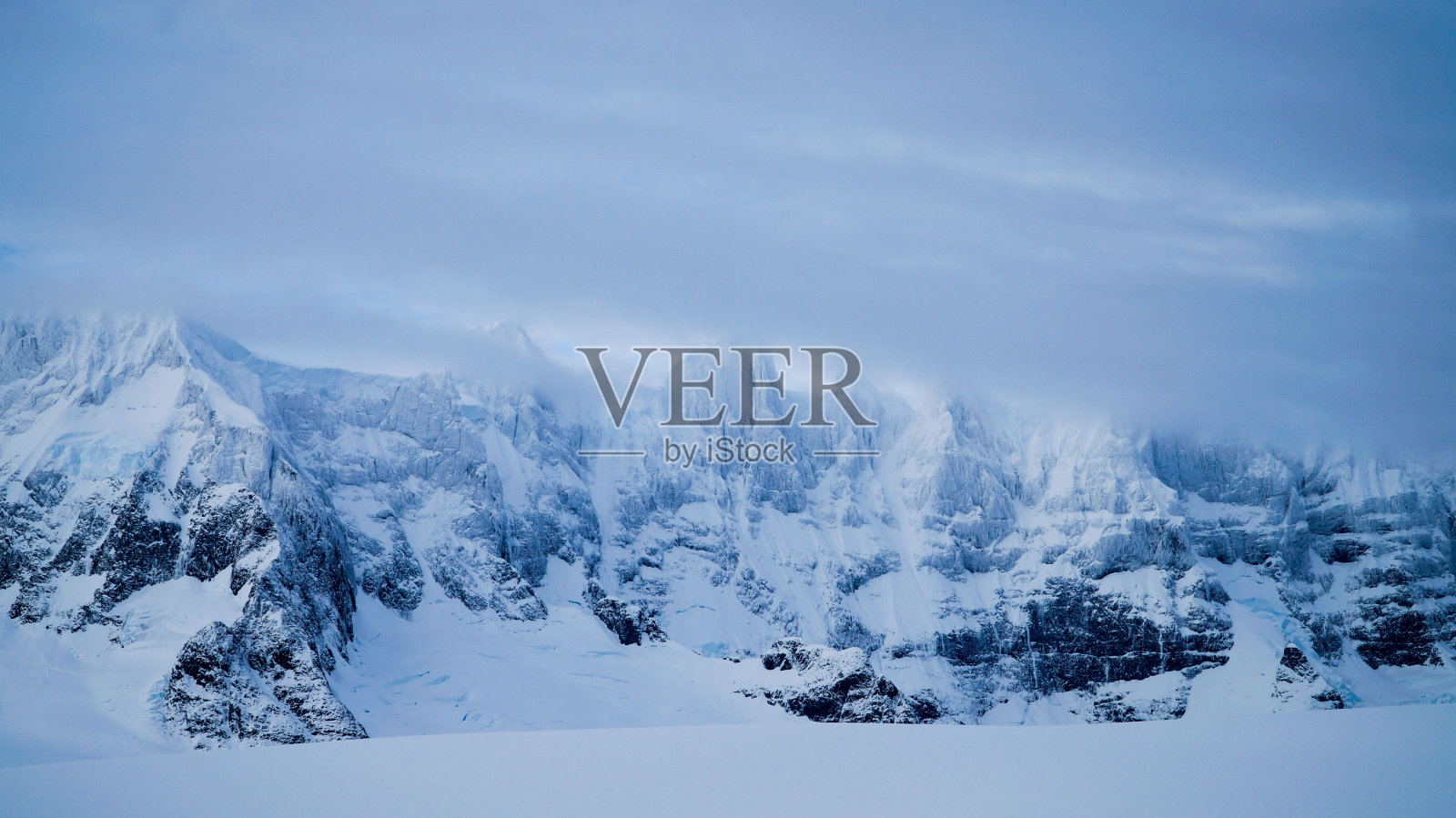 南极洲半岛上冰雪覆盖的山脉和冰山。照片摄影图片