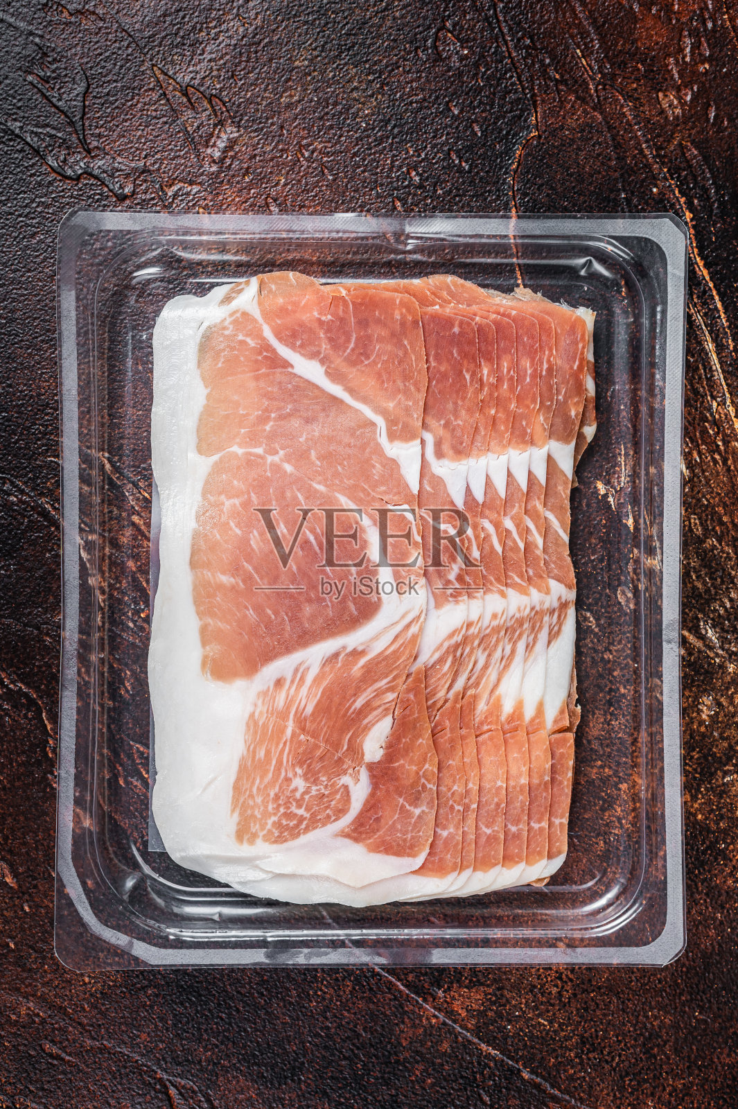 真空包装的意大利熏火腿或火腿。黑暗的背景。俯视图照片摄影图片