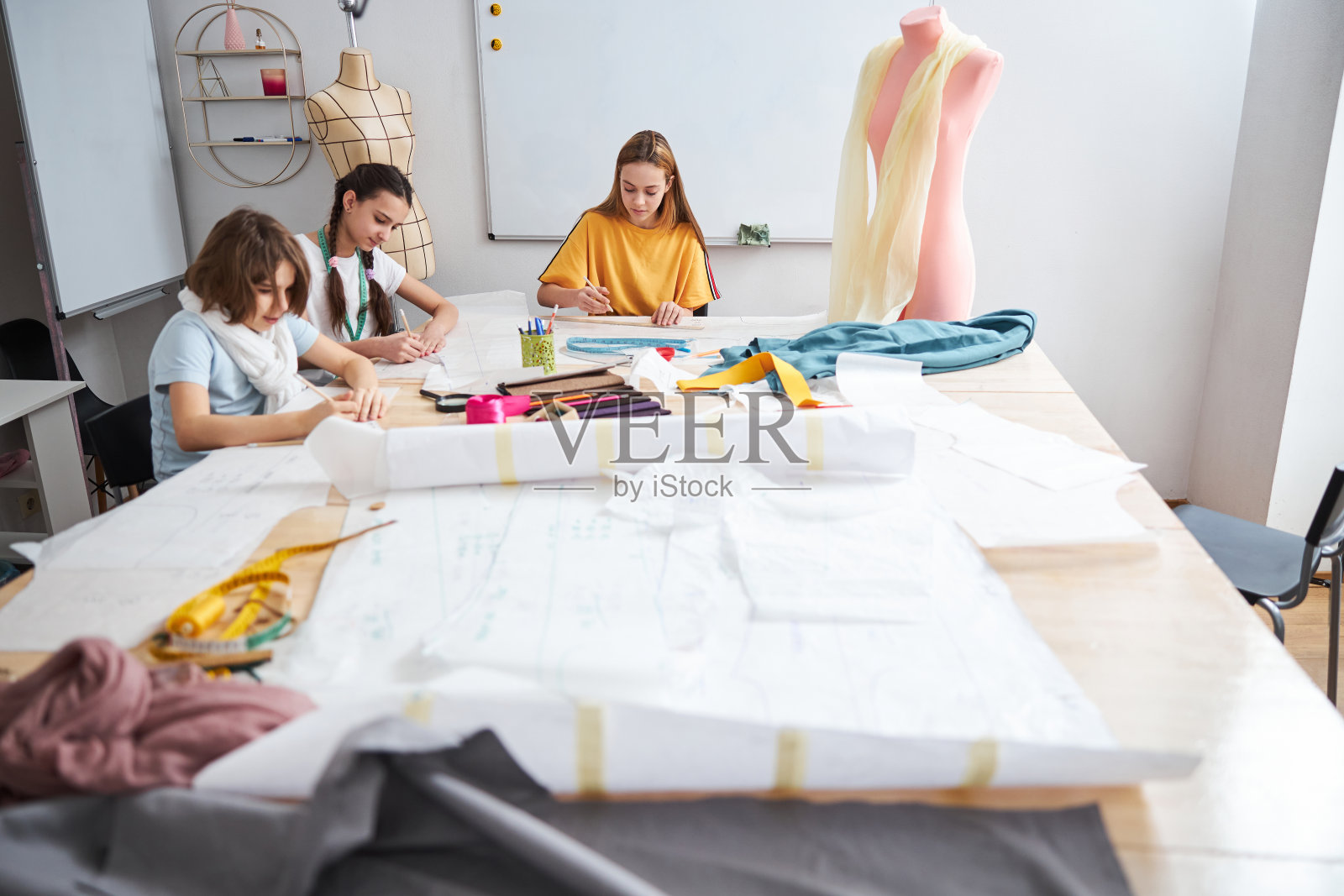 三个可爱的女孩在缝纫车间工作照片摄影图片