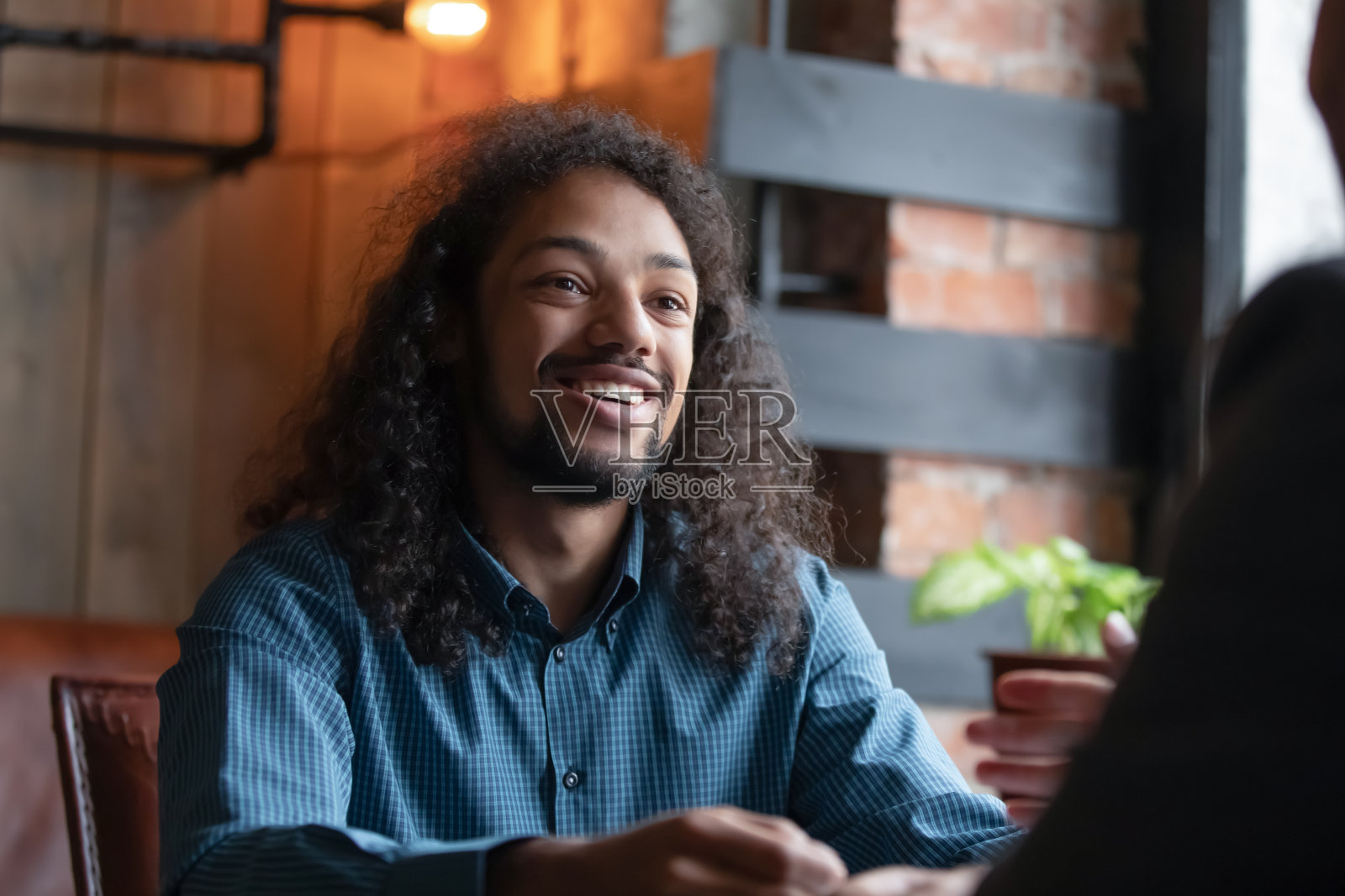 年轻的混血儿男子休息在咖啡馆和朋友聊天照片摄影图片