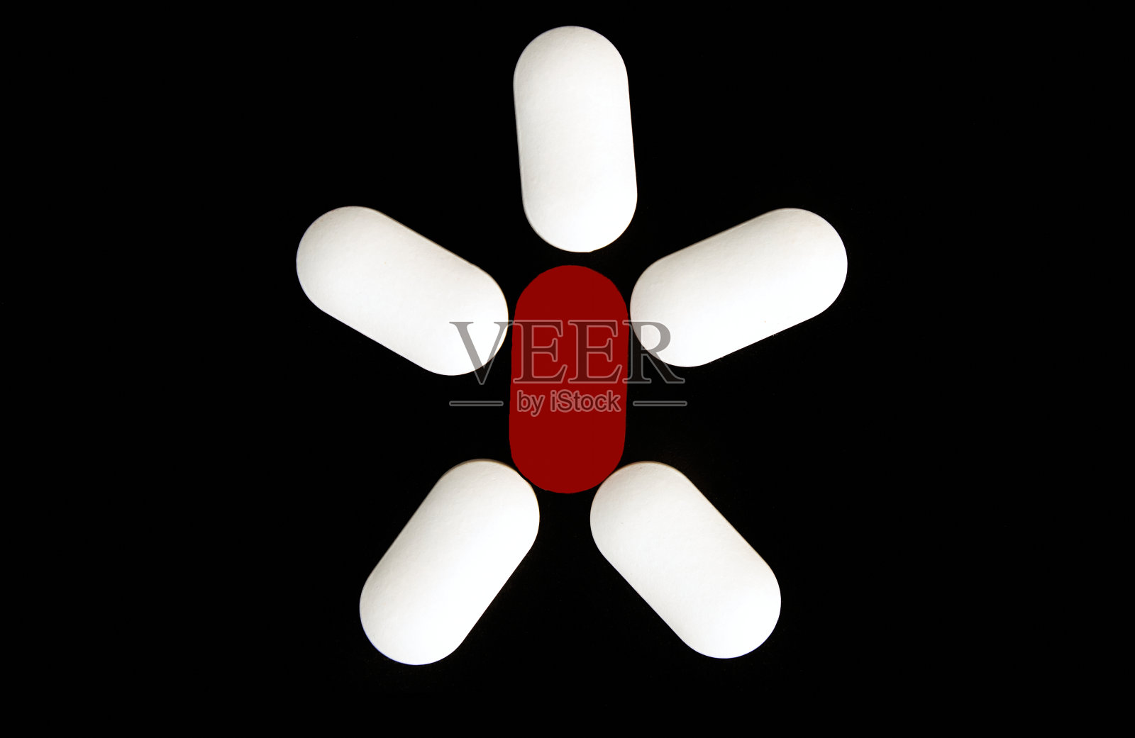 一个男人把药丸放在黑色背景上。照片摄影图片