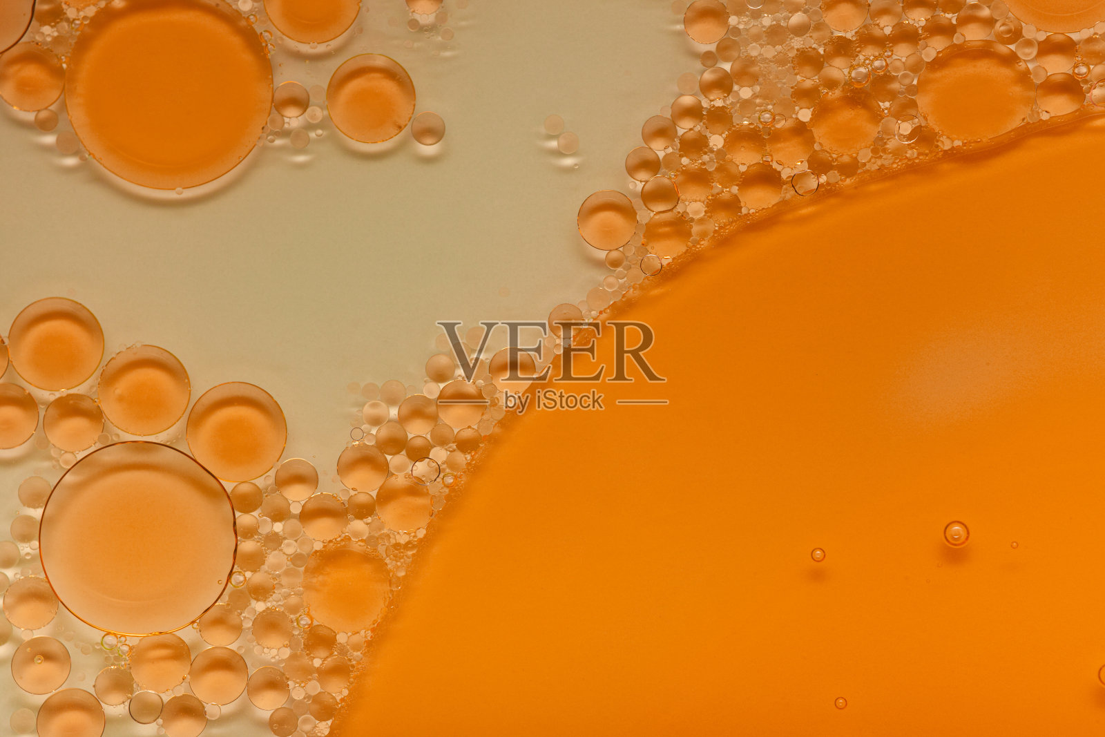 明亮的液体橙色凝胶或油精华血清乳剂泡沫白色和多色孤立背景照片摄影图片