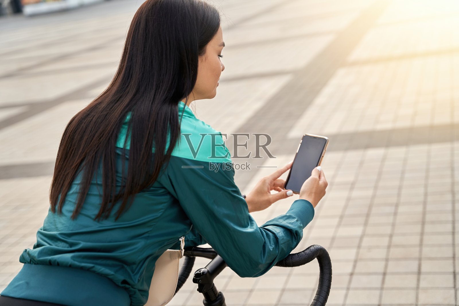 靠在自行车把手上用电话的漂亮女士照片摄影图片