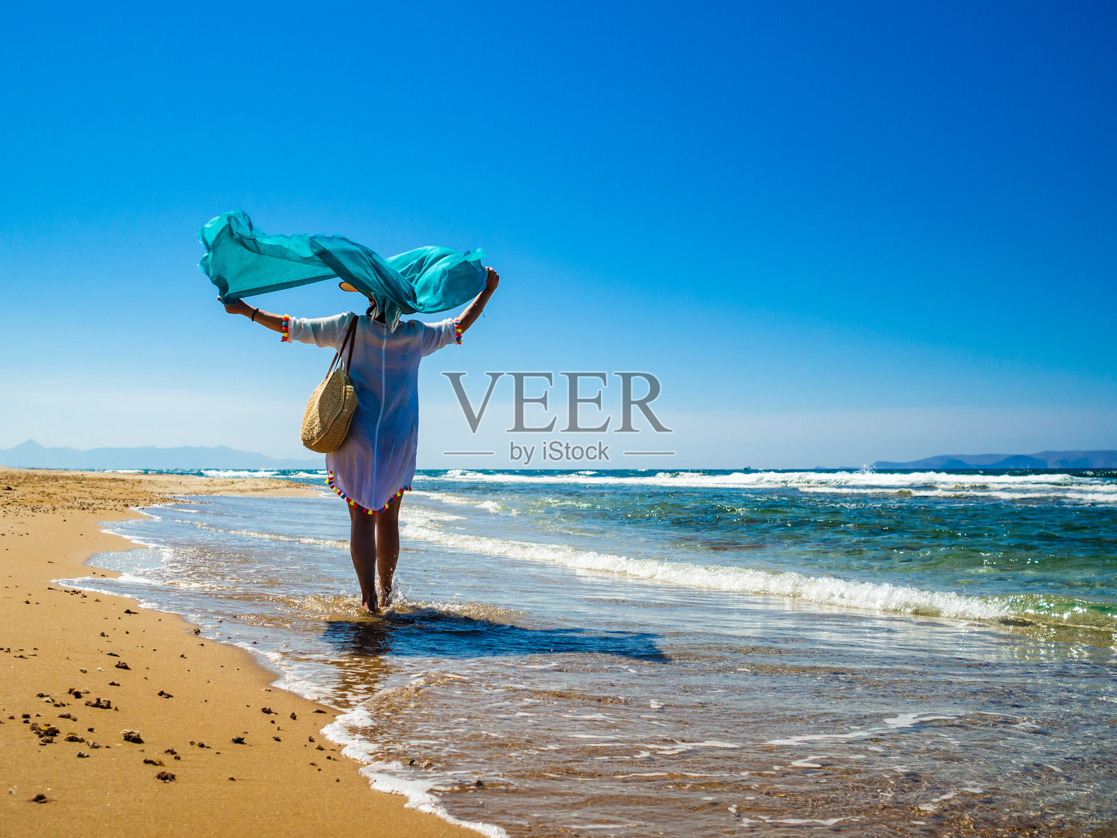 在希腊海边散步的女人照片摄影图片