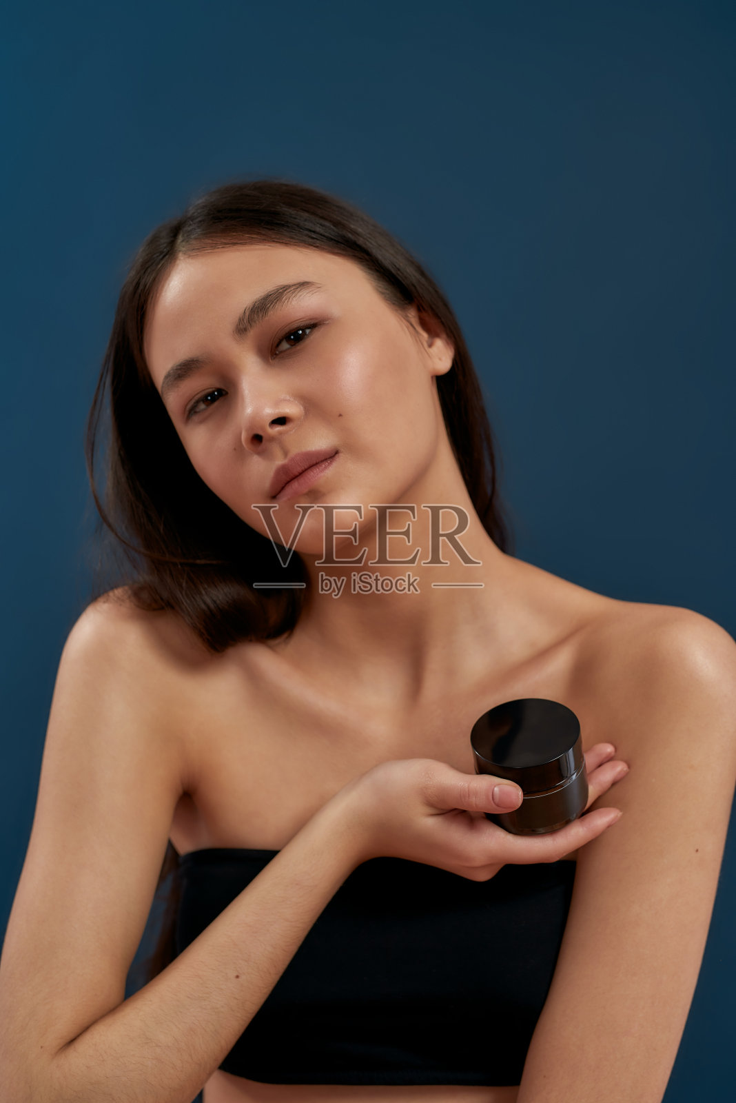 一个手里拿着一瓶奶油的年轻女孩照片摄影图片