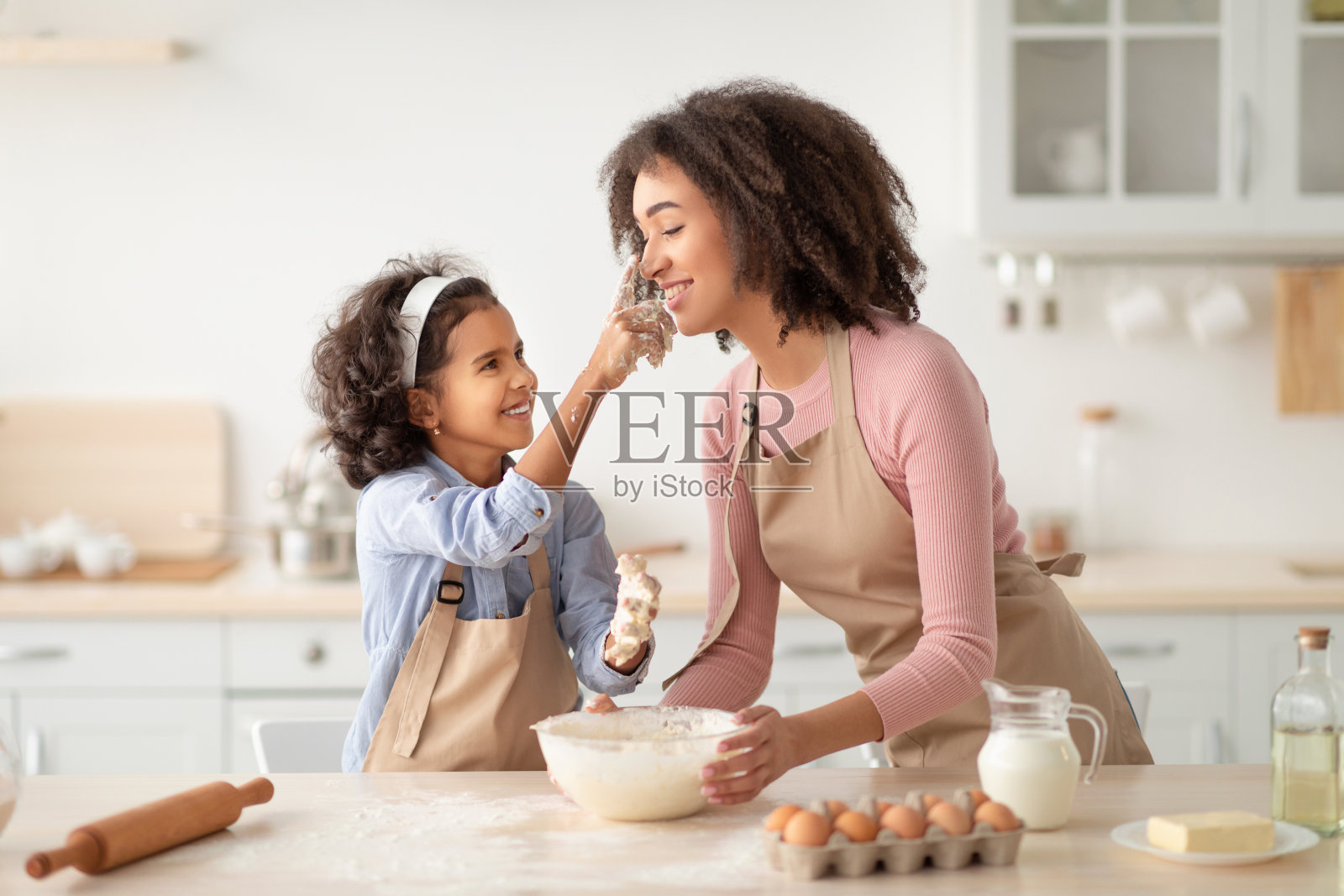 黑人妇女和女儿在做饭和玩面粉照片摄影图片