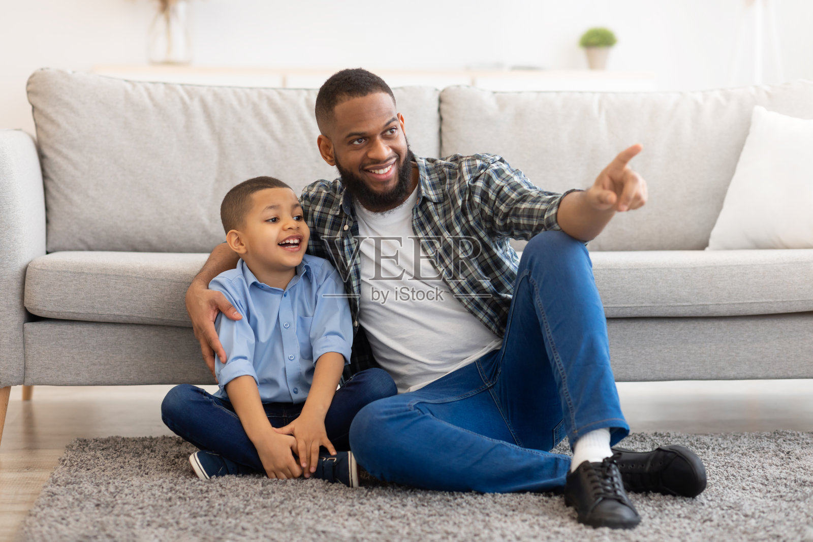 非洲父亲和儿子坐在家里地板上拥抱照片摄影图片